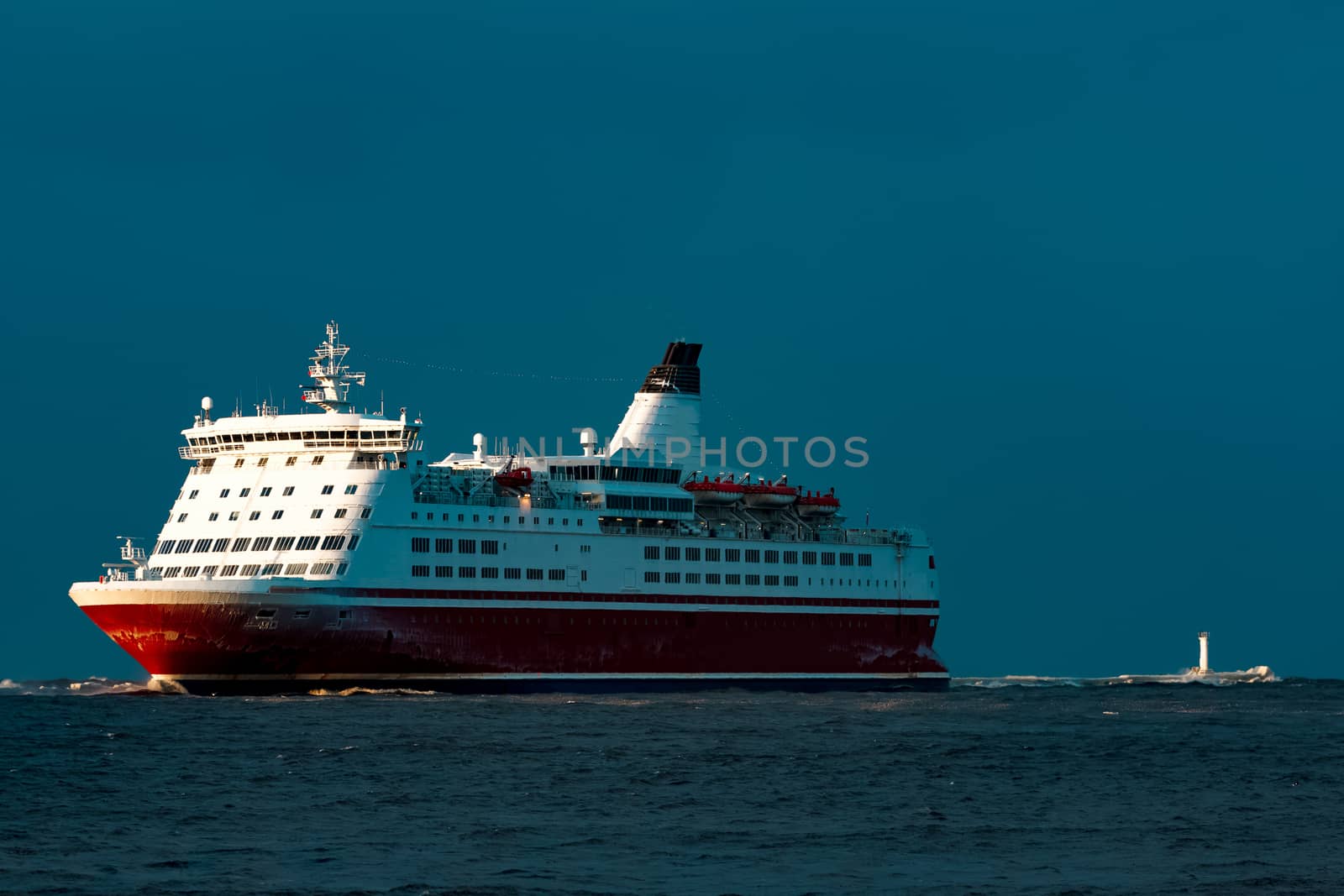 Red cruise liner. Passenger ship sailing from the sea in the morning