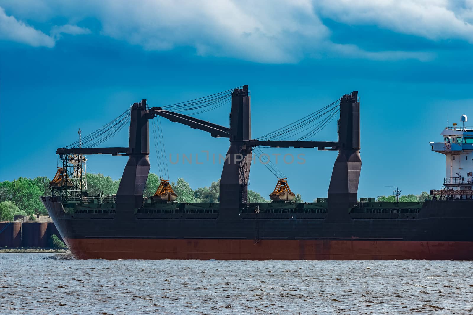 Merchandise import. Large blue cargo ship moving to Riga port