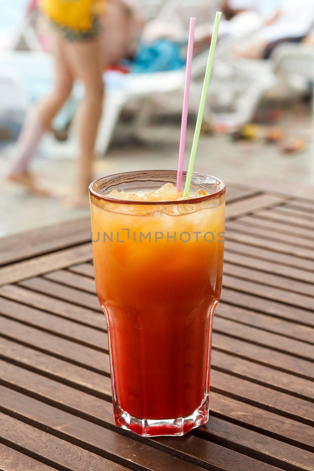 Cocktail with straw on the wooden table.