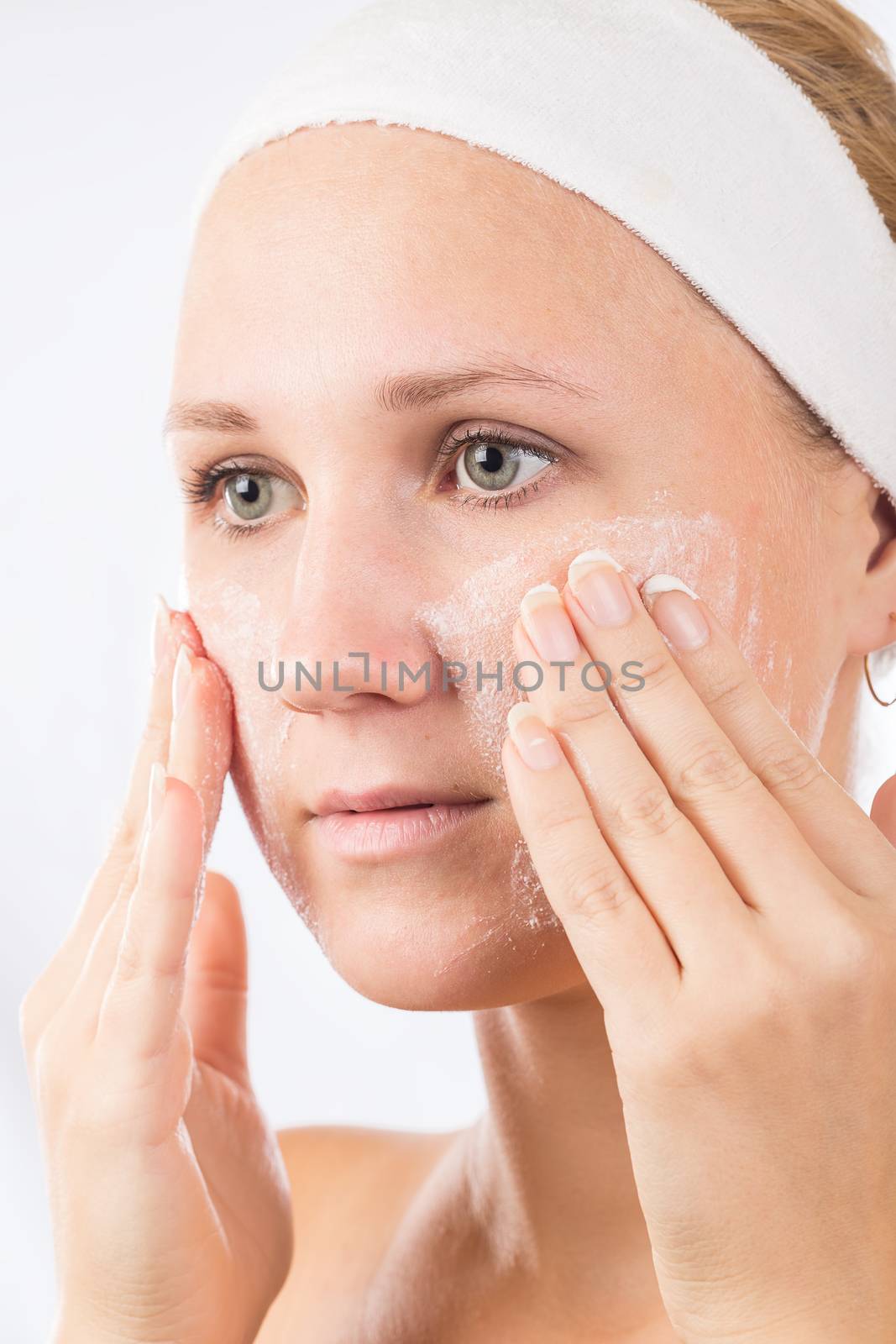 A young girl makes a face mask.