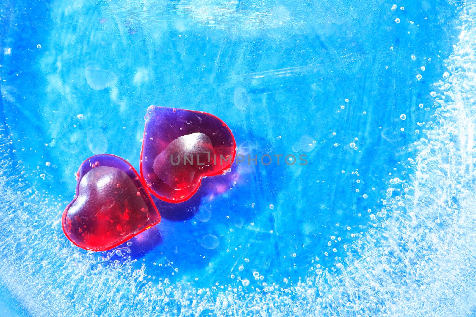 Valentines Day greeting card. Two red hearts in blue frozen water with free space