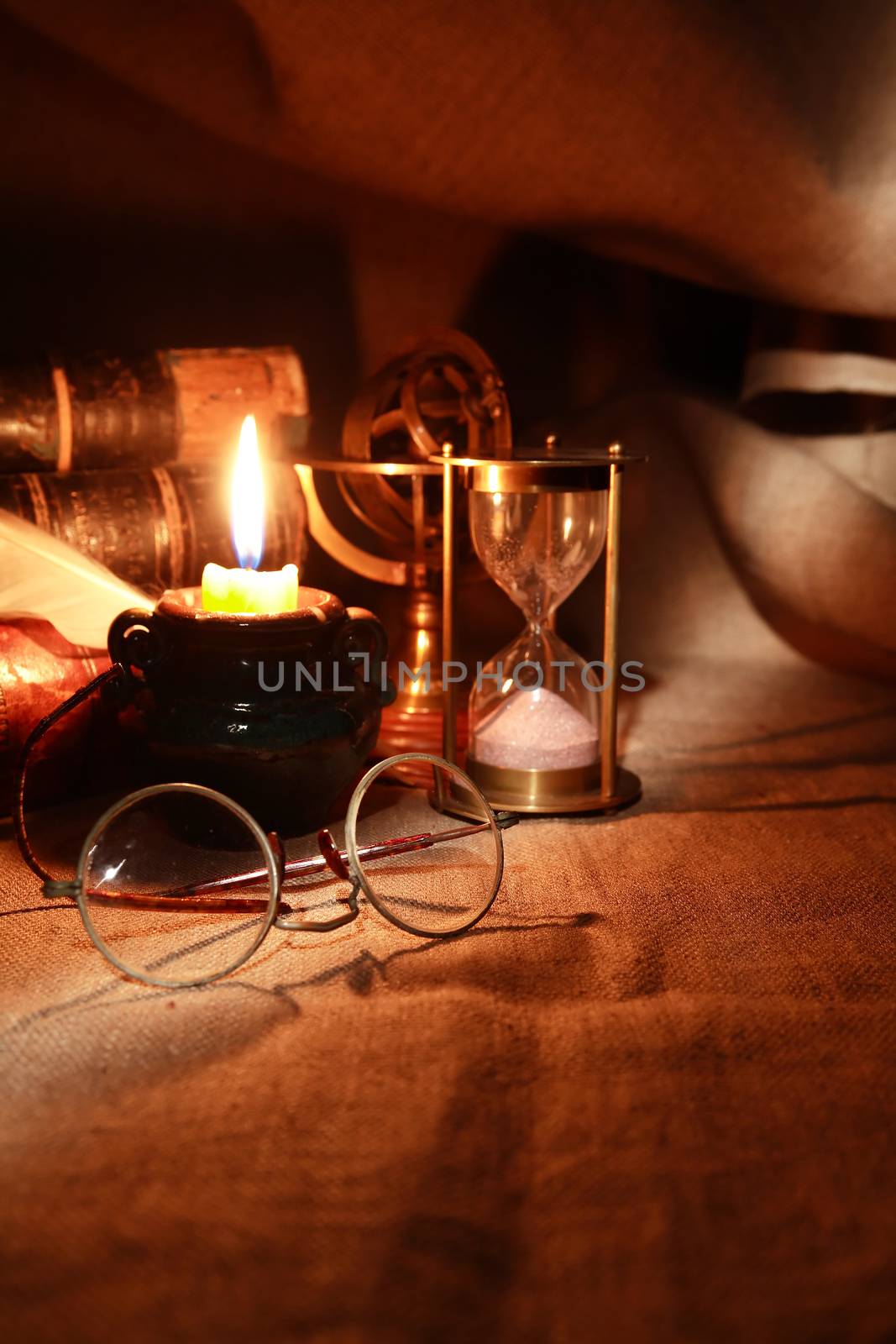Vintage still life with lighting candle near old things