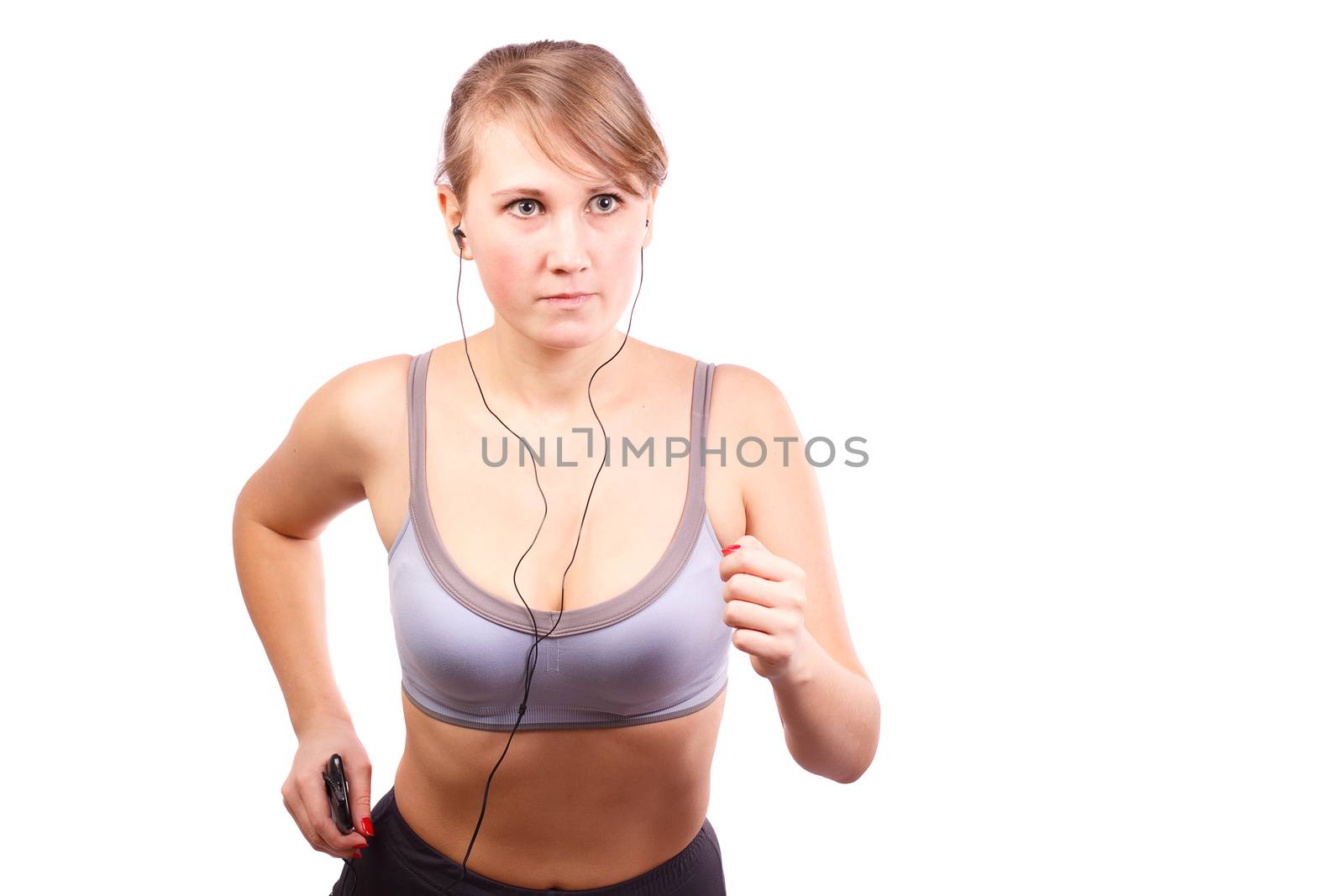 Woman runs on a white background, in her ears headphones.
