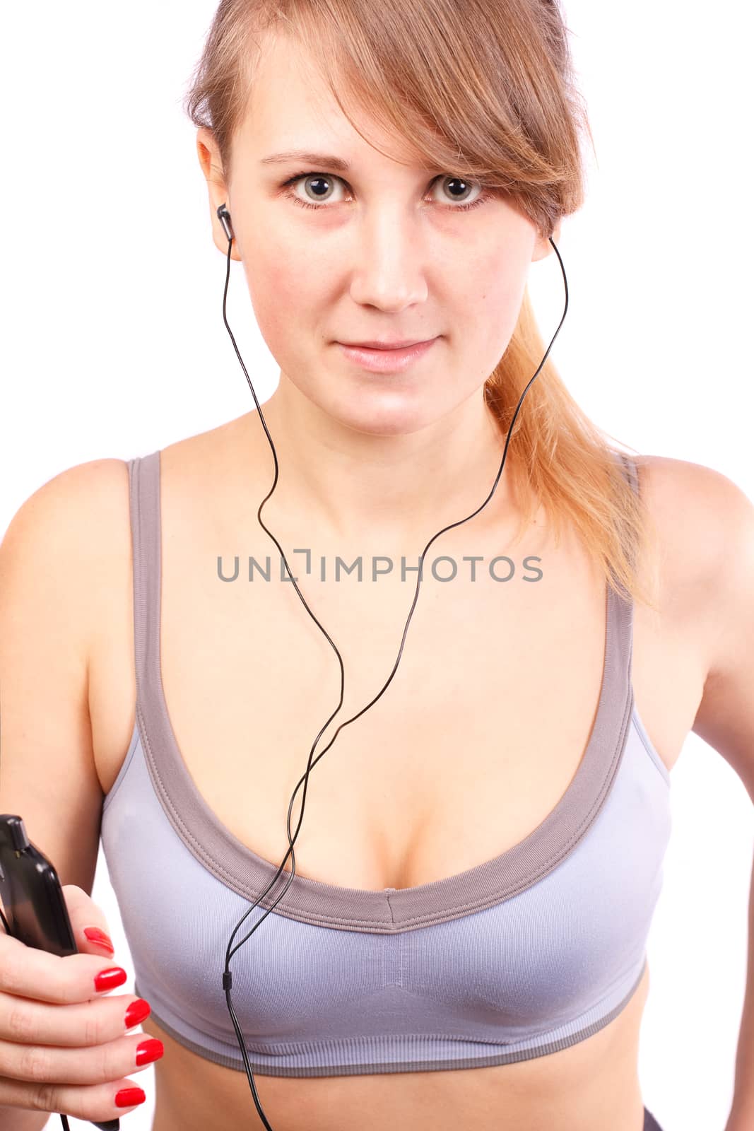 Woman runs on a white background, in her ears headphones.