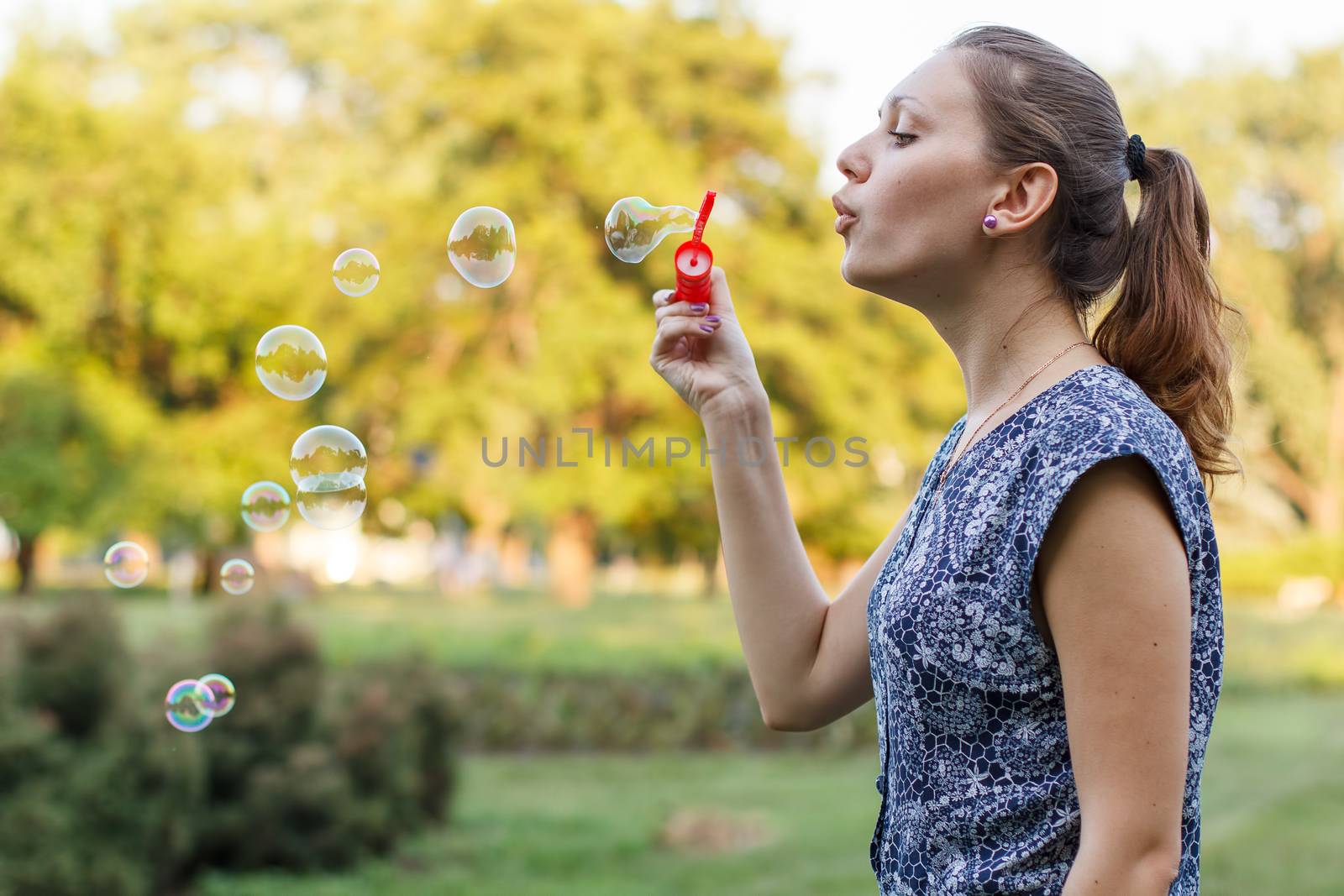 Beautiful girl in the park with soap bubbles.