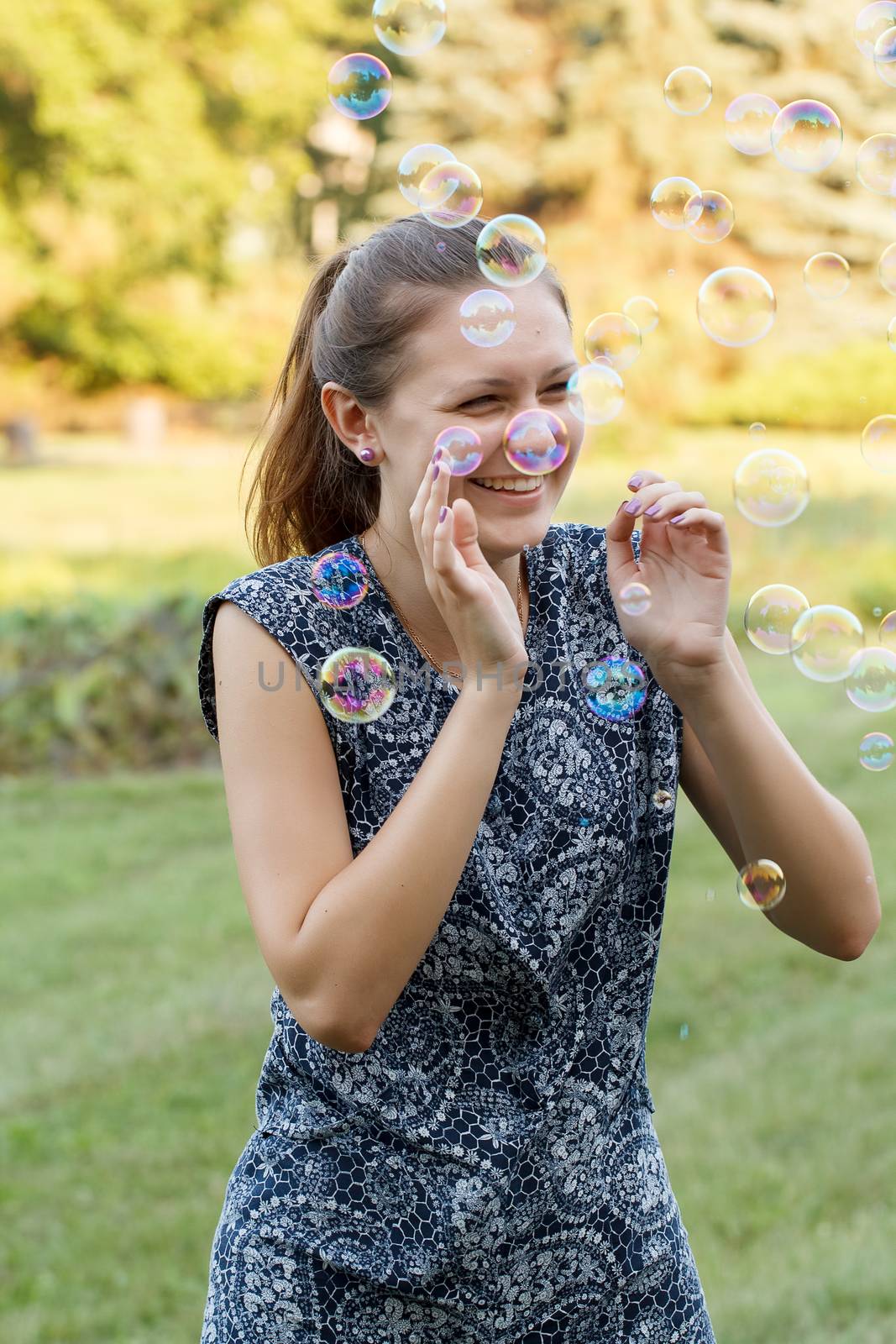 Beautiful girl in the park with soap bubbles.