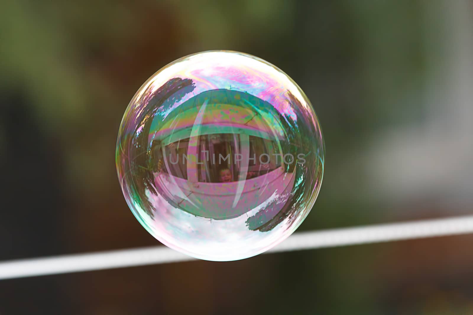 Soap ball in daylight against a background of greenery.