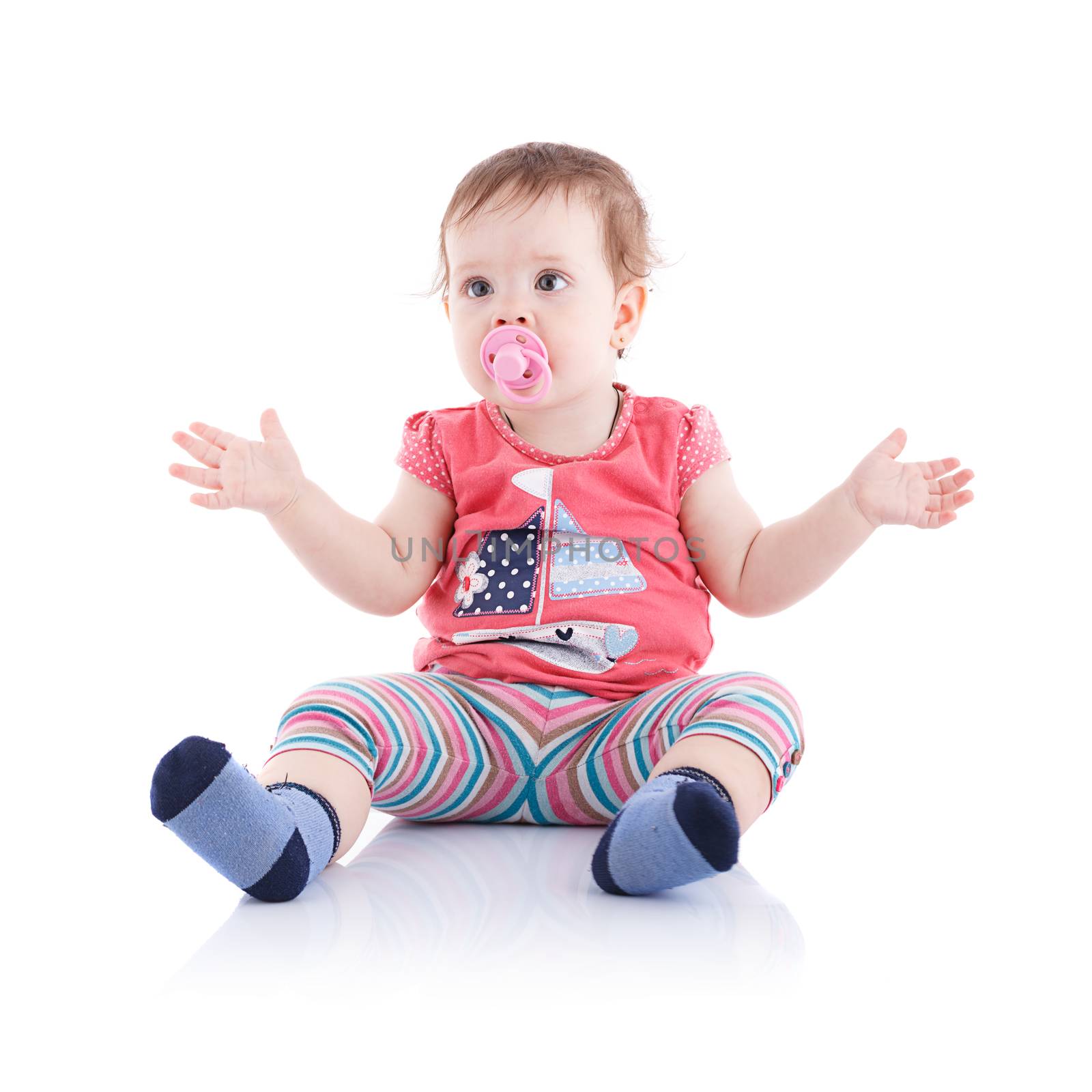 The girl is one year in dress sitting on a white background.