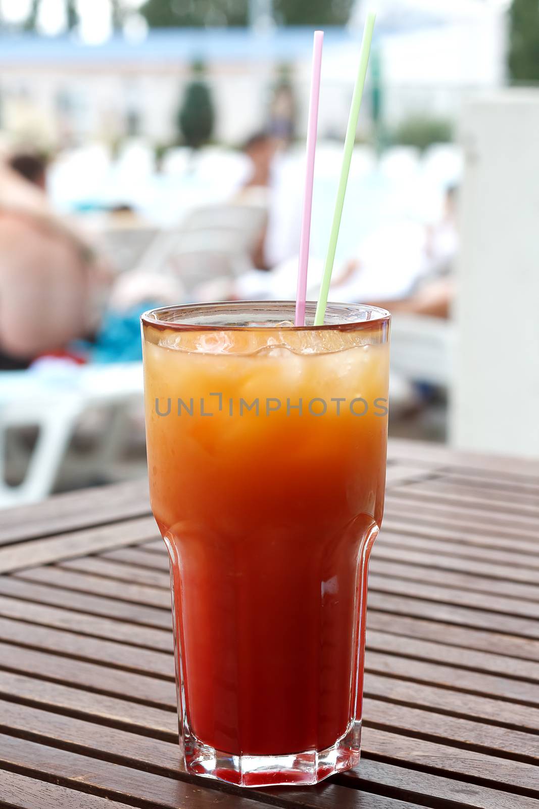 Cocktail with straw on the wooden table.