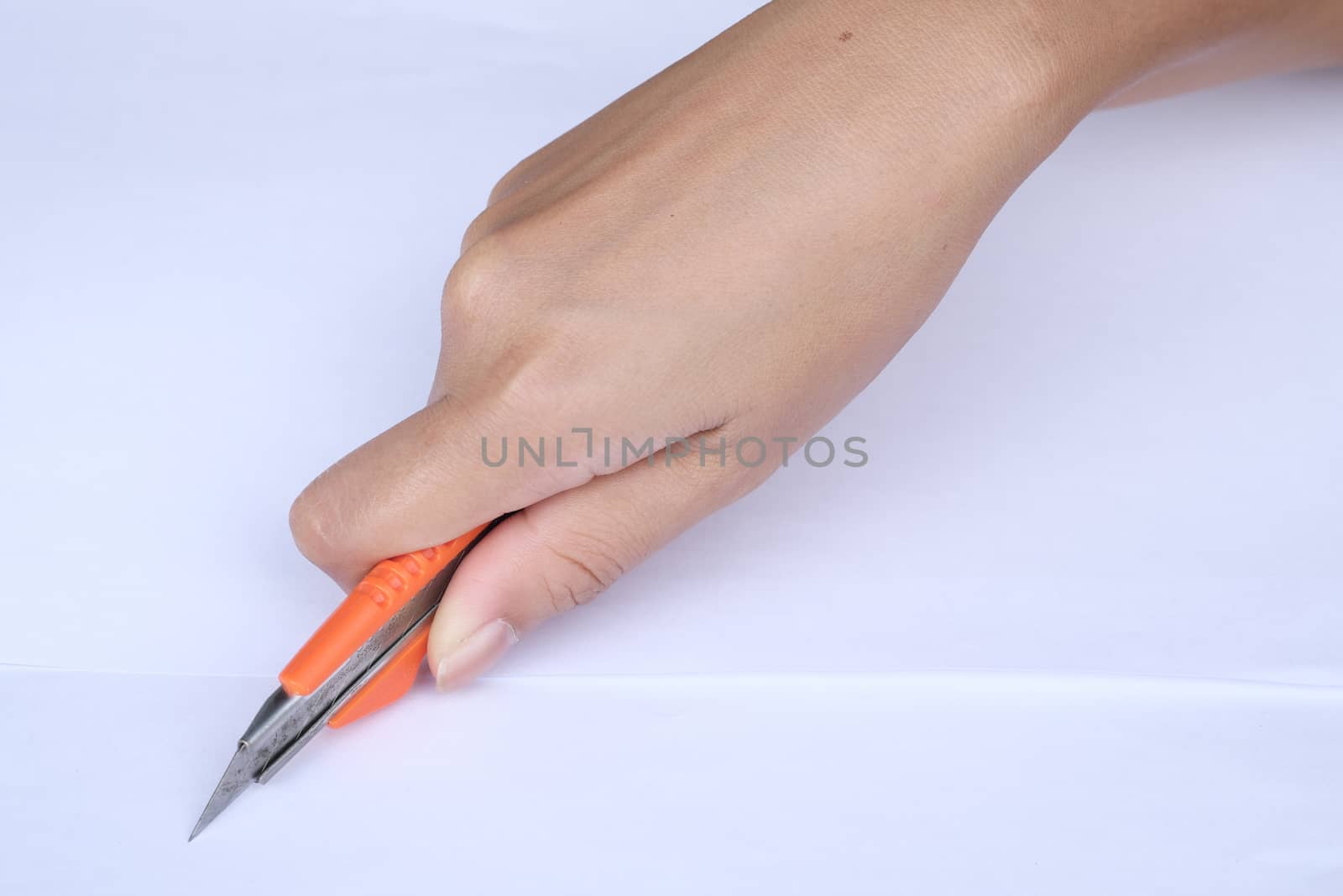 women hands cutting carton with a knife on a paper. Close up handwork.