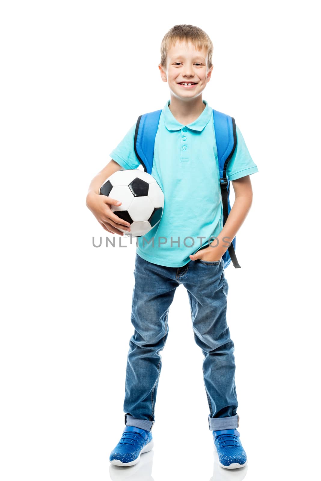 happy schoolboy holding a football ball isolated in full length on a white background