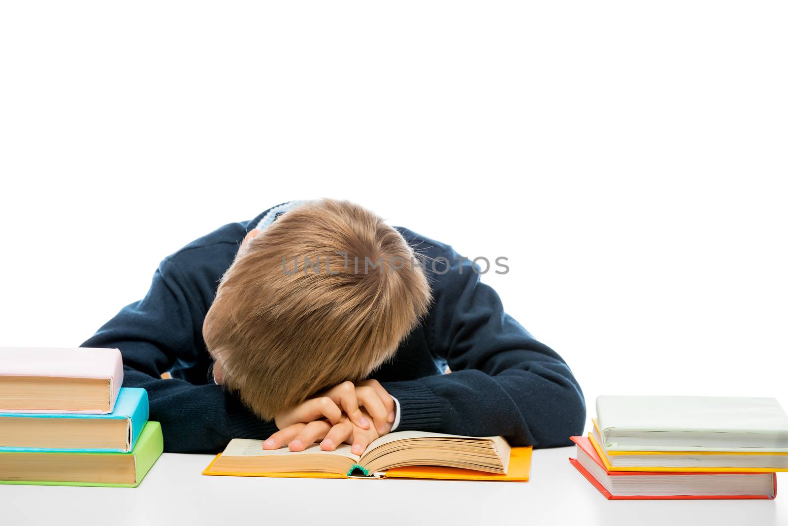 a tired schoolboy fell asleep while reading a book at the table by kosmsos111