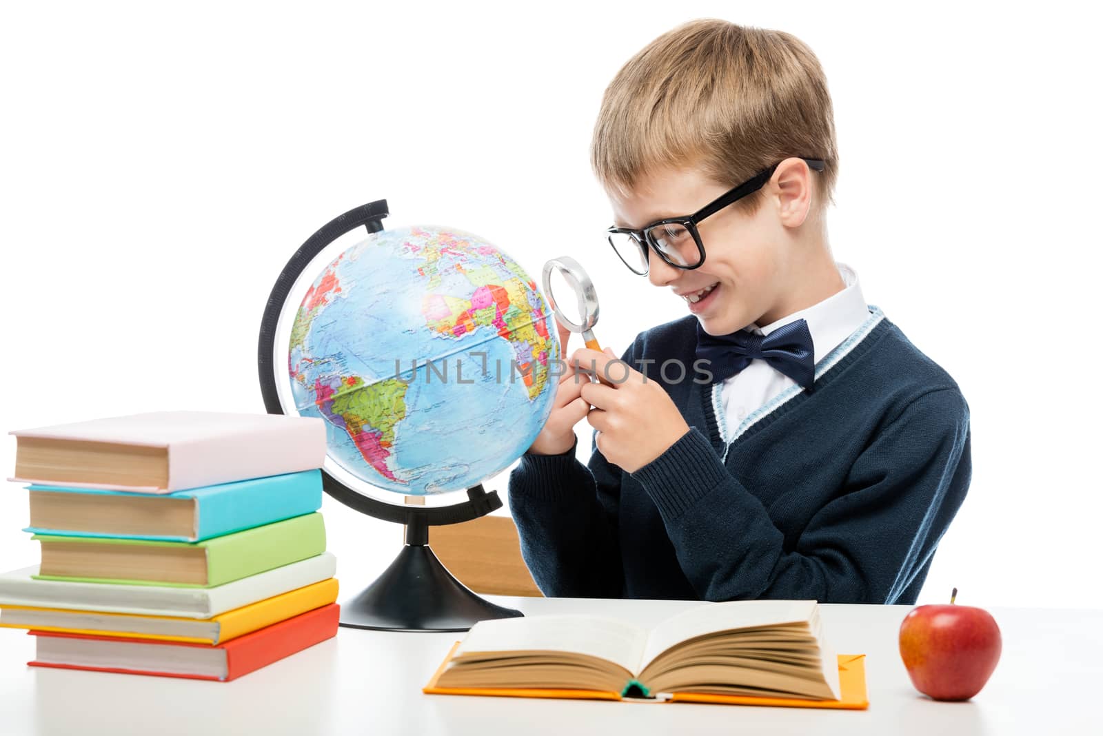 cheerful schoolboy with a magnifying glass examines the globe at by kosmsos111