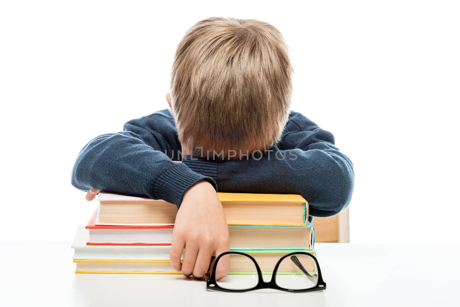 a tired little schoolboy fell asleep on books during a lesson