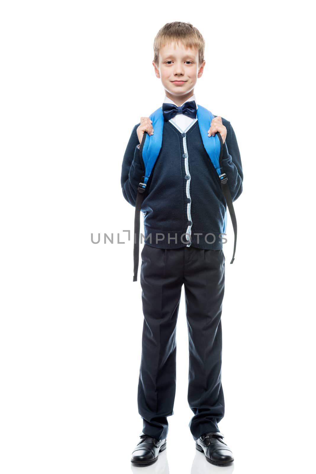 vertical portrait of a schoolboy with a backpack in the form in full length isolated