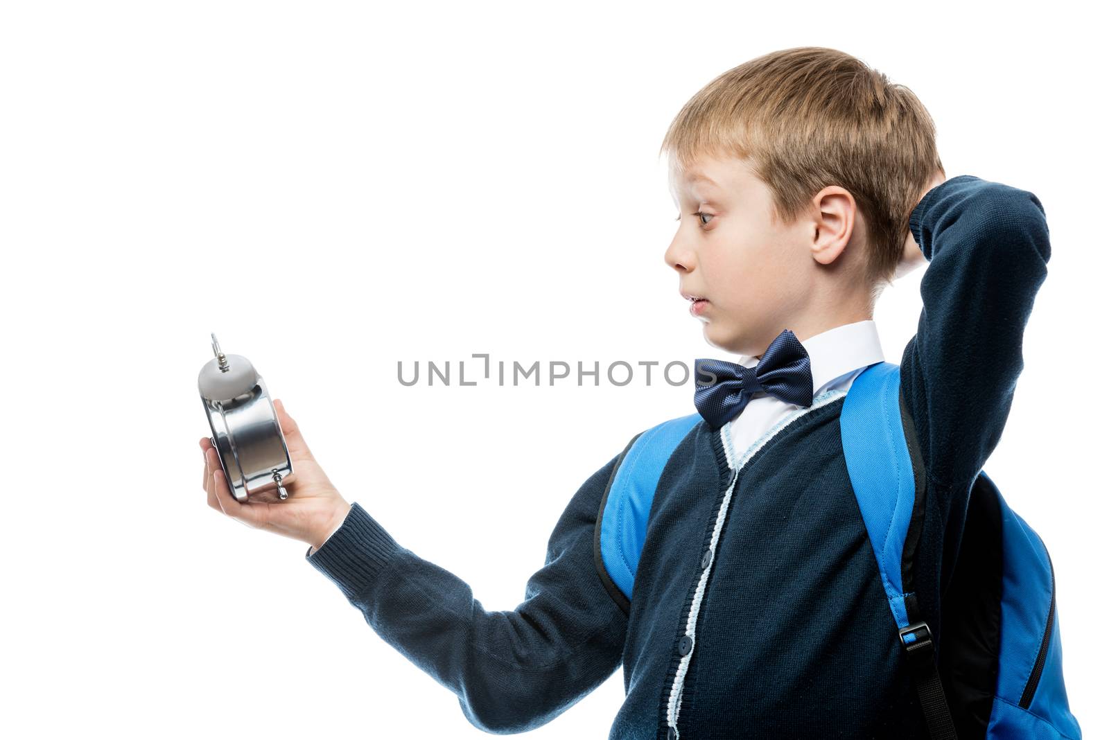 surprised schoolboy watching time on alarm clock, portrait isolated