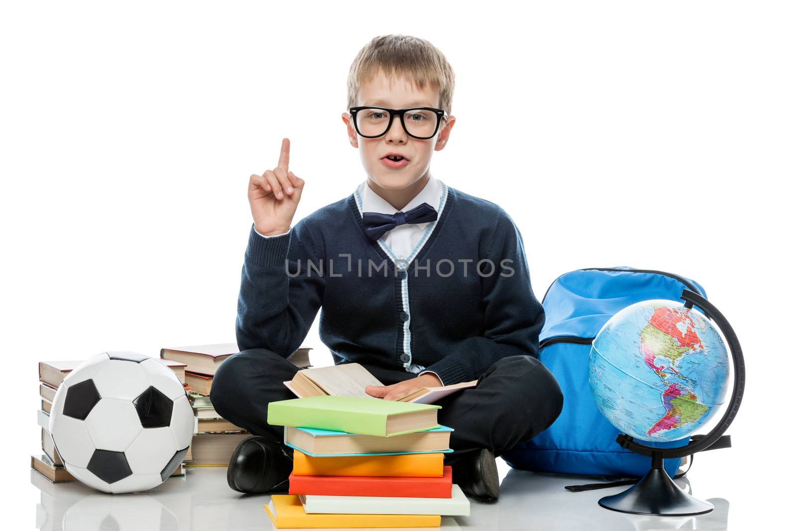 schoolboy posing on white background with a bunch of books