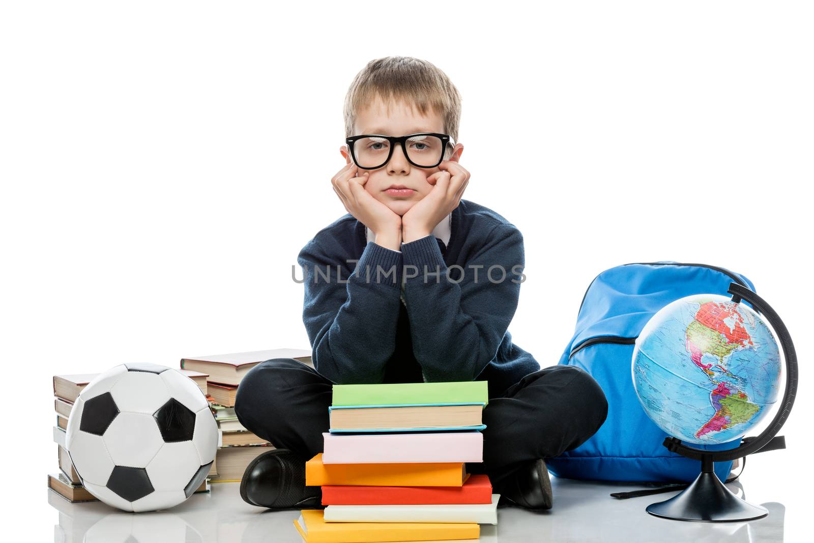 horizontal portrait of a schoolboy with books and globe on a white background in studio