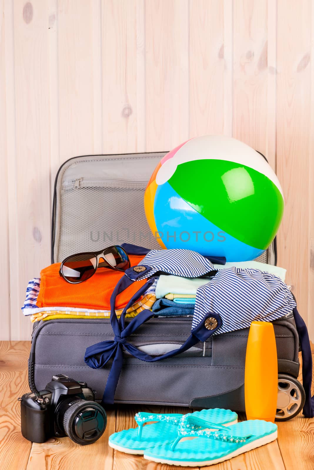 everything necessary for a good holiday at sea, objects in a suitcase on a wooden table