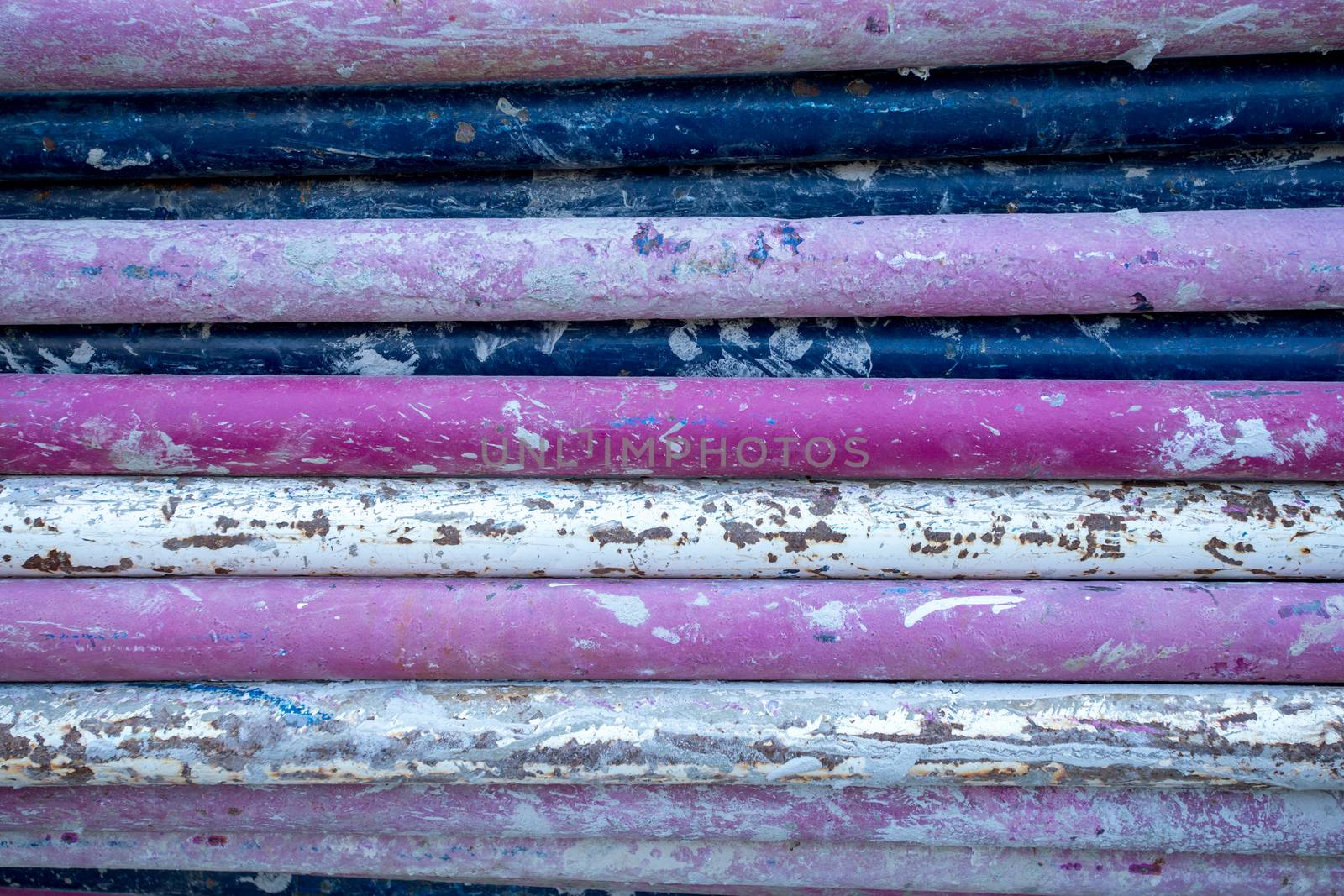 heap of dirty purple steel pipes of construction materials