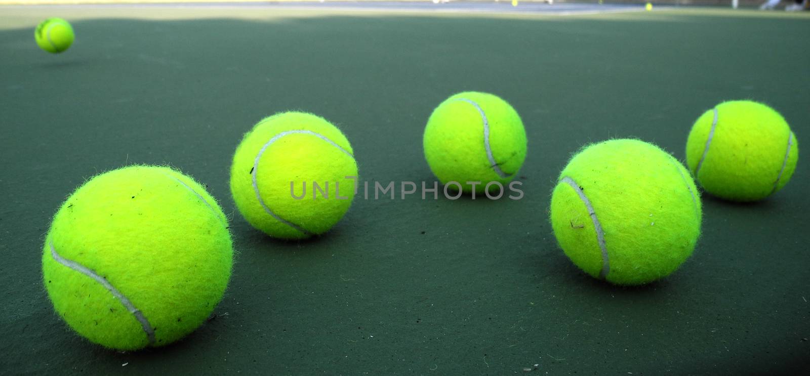 Group of six tennis balls on tennis court