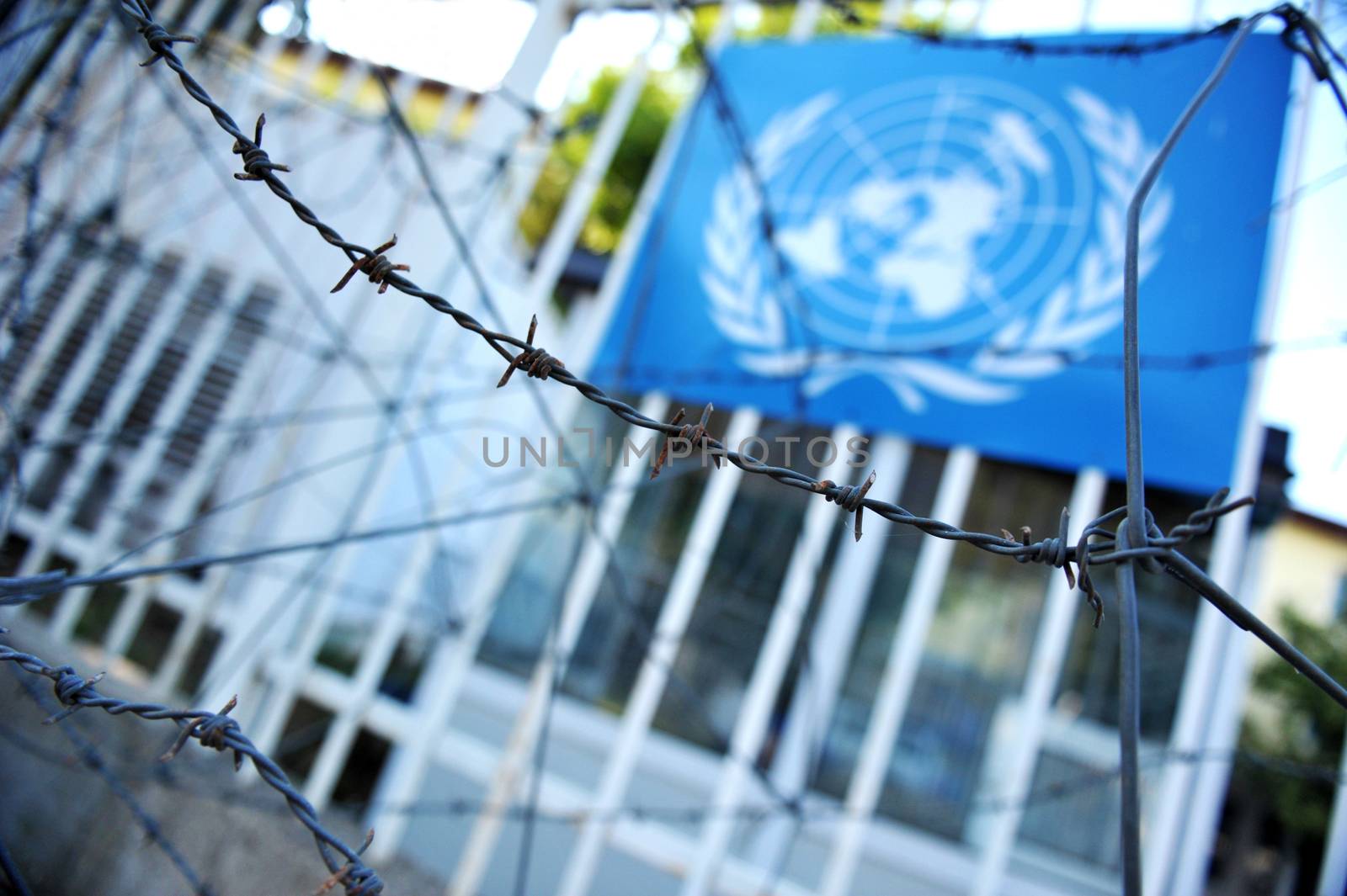 Blured United Nations flag trough barbed wire