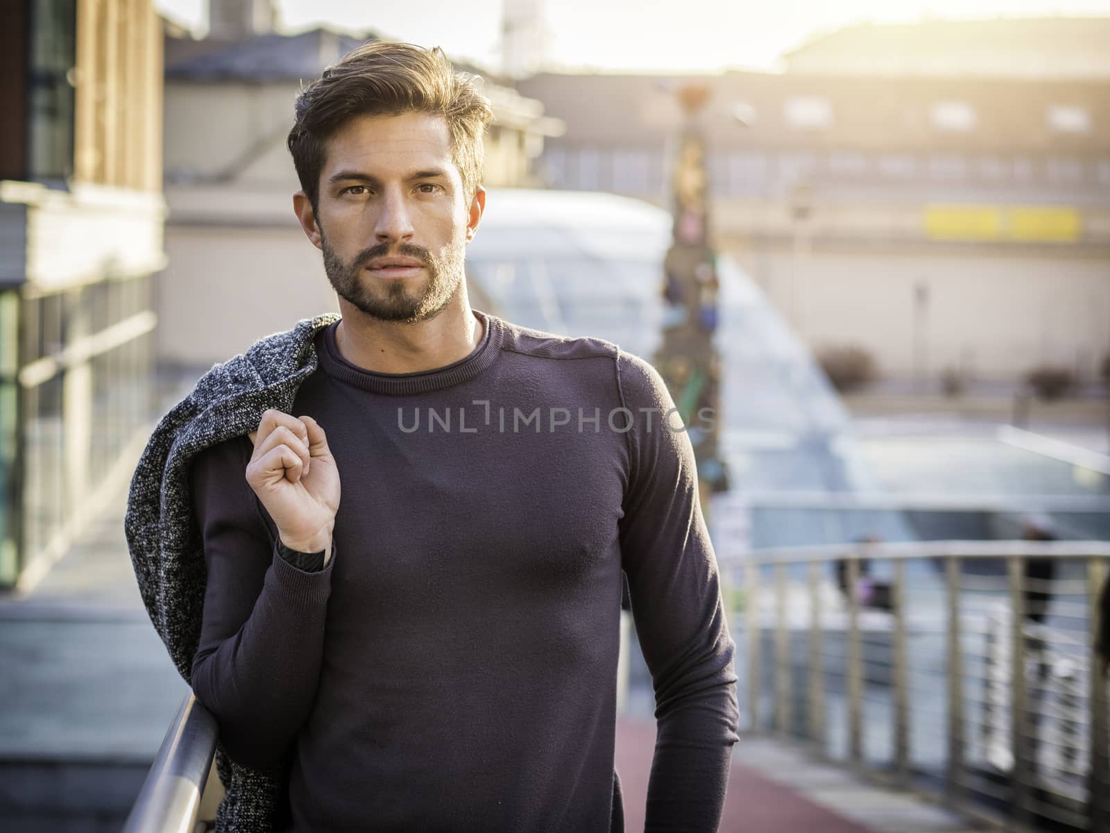 One handsome young man in urban setting in European city, standing