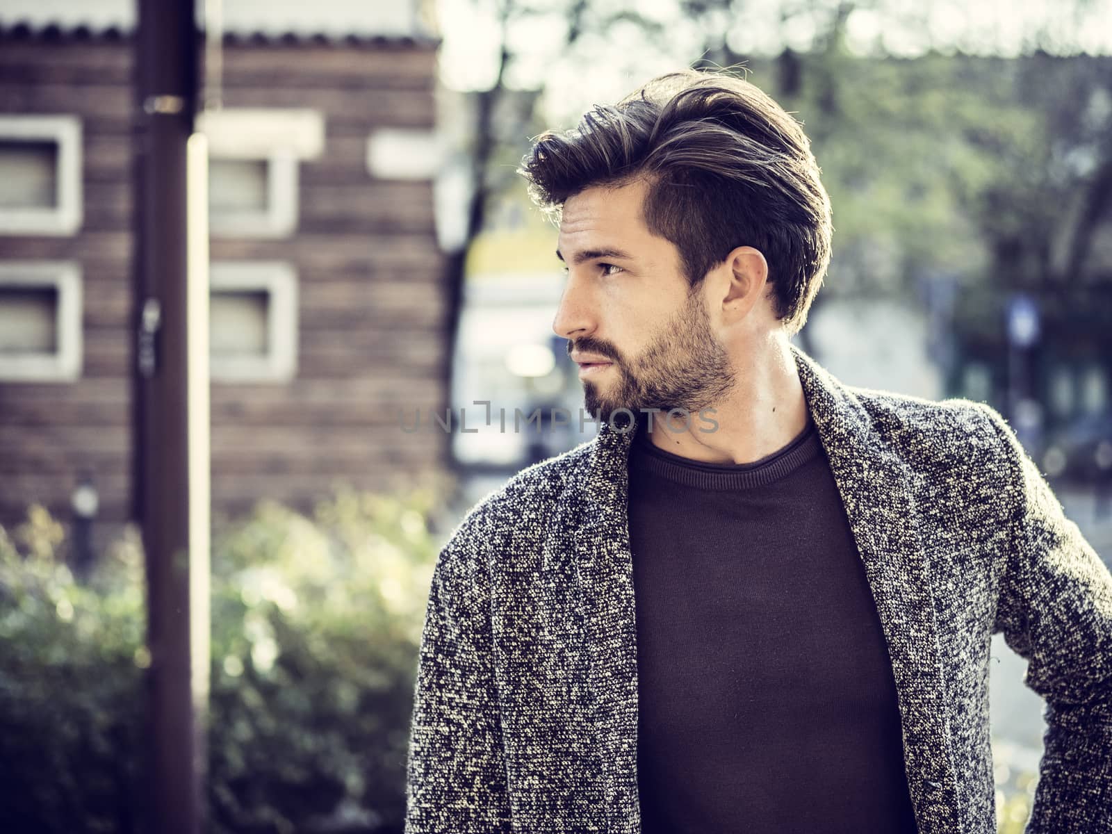 One handsome young man in urban setting in European city, standing