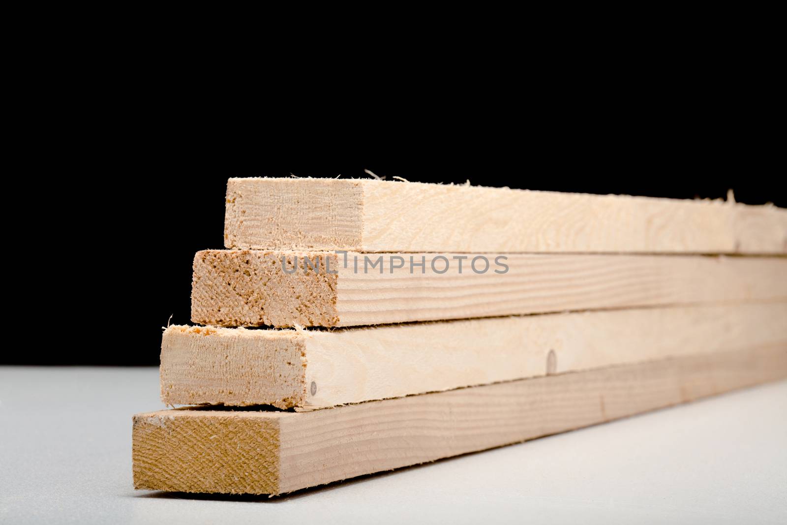 four wooden beams on white surface, black background