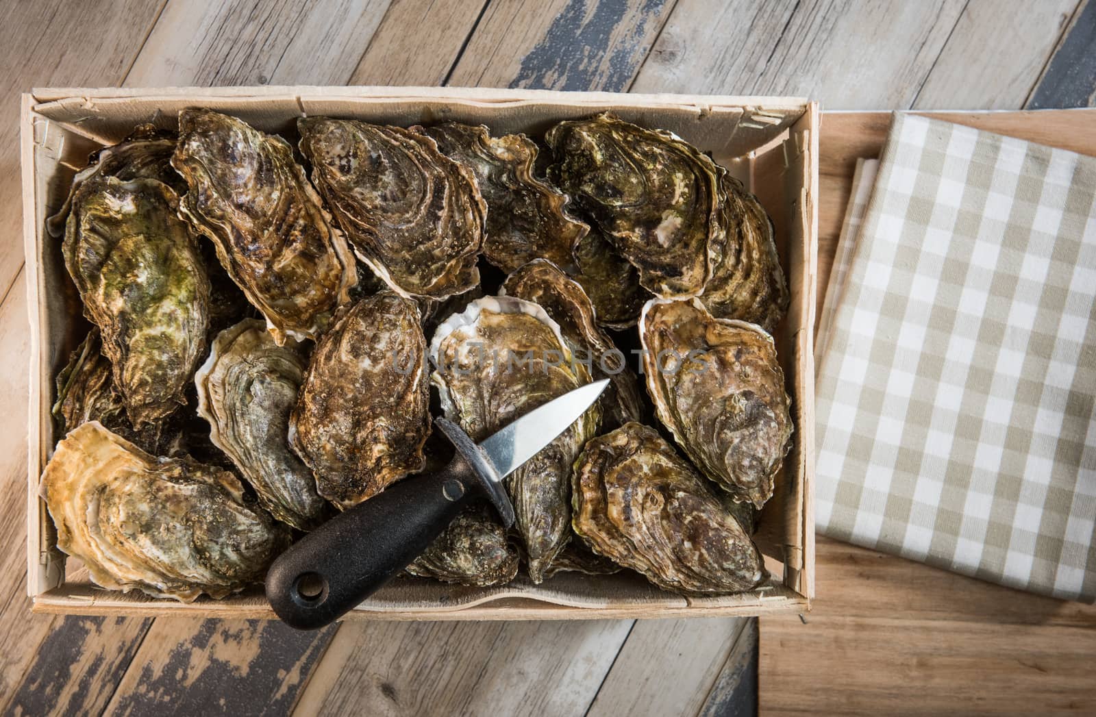 Raw oysters with lemon on wood board and bottle of wine and glass, France