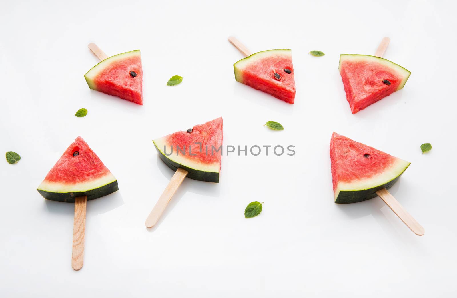 Watermelon slice popsicles and paper mint on white wooden backgr by Bowonpat