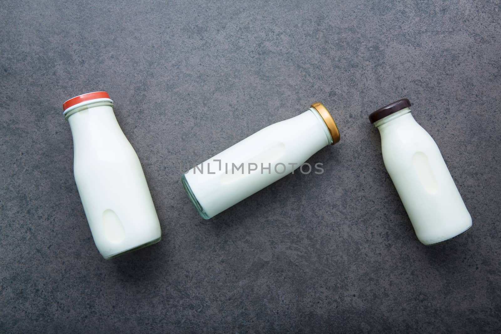 Milk bottle on dark stone background. Top view with copy space.