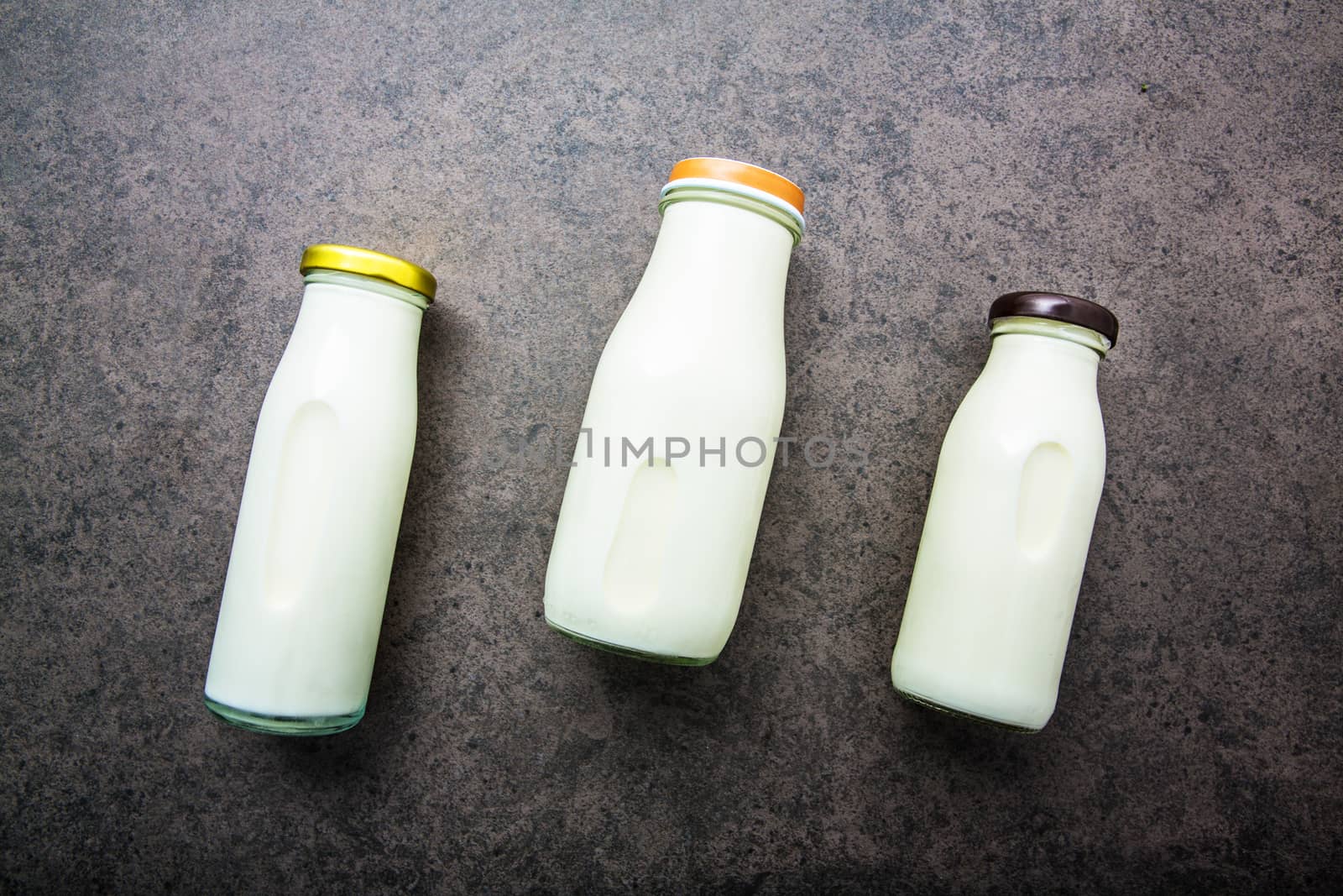 Milk bottle on dark stone background. Top view with copy space.