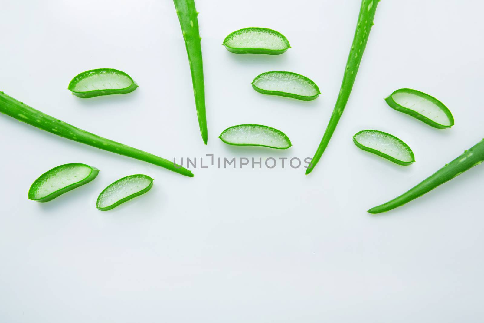 Aloe vera fresh leaves with slices aloe vera gel on wooden spoon. isolated over white 