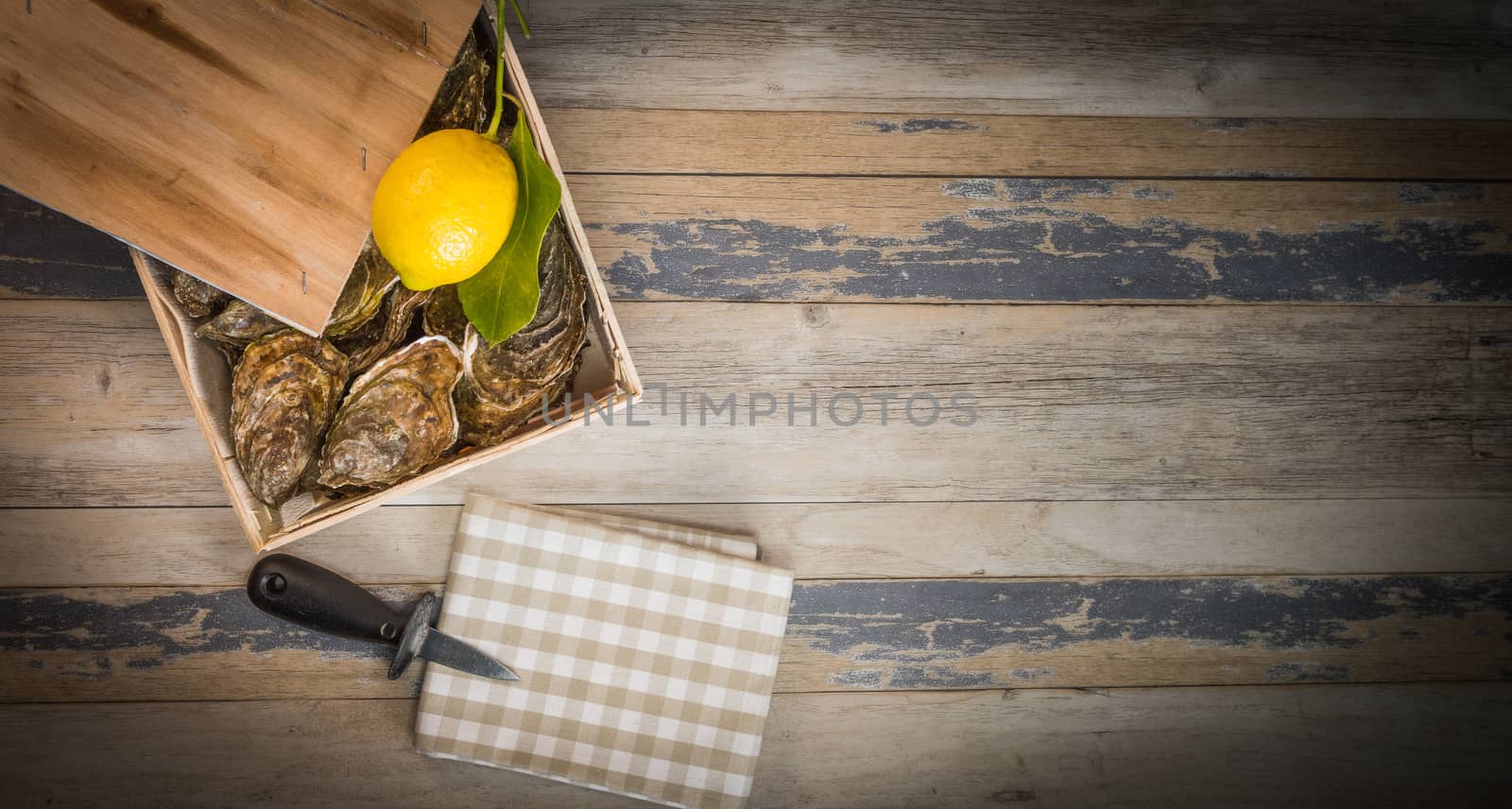 Raw oysters with lemon on wood board and bottle of wine and glass, France