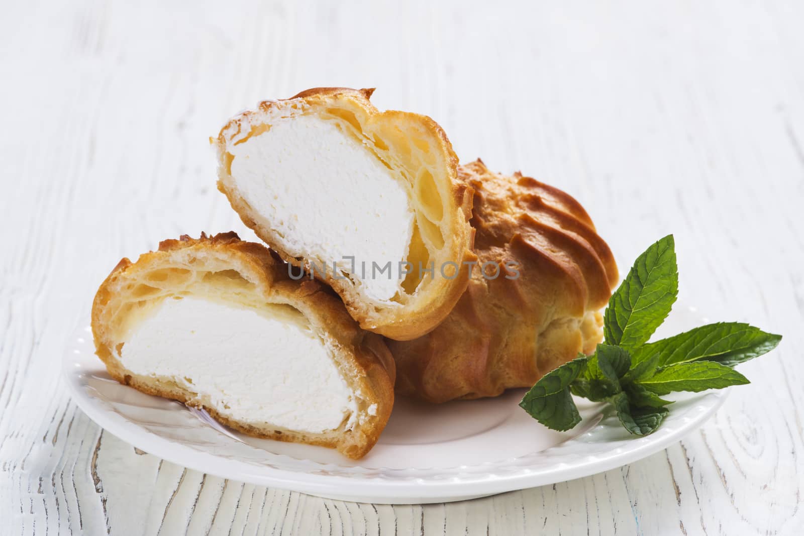 Profiteroles on plate on a table on wooden background