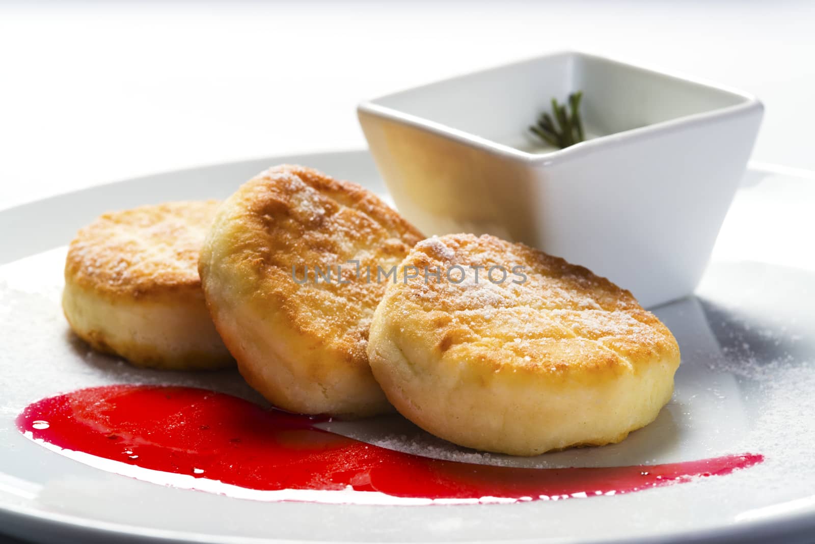 Cottage cheese pancakes with jam on plate