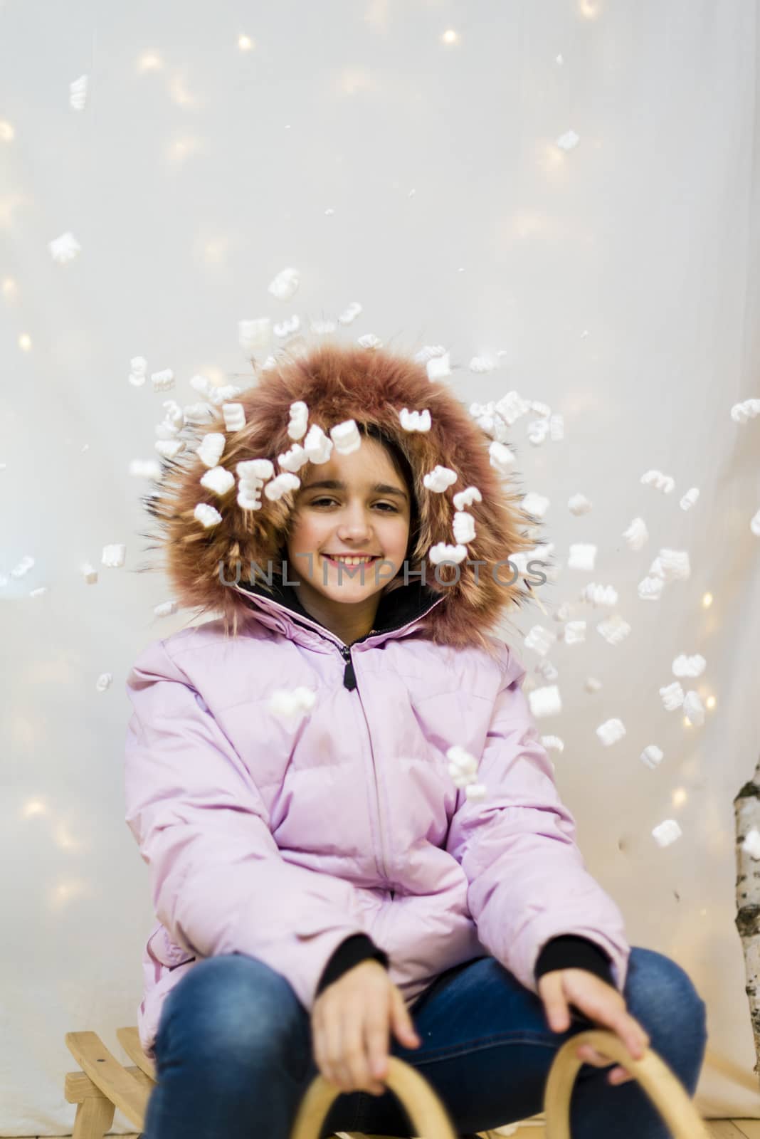 portrait of teenager in studio with pink winter jacket with fur hood