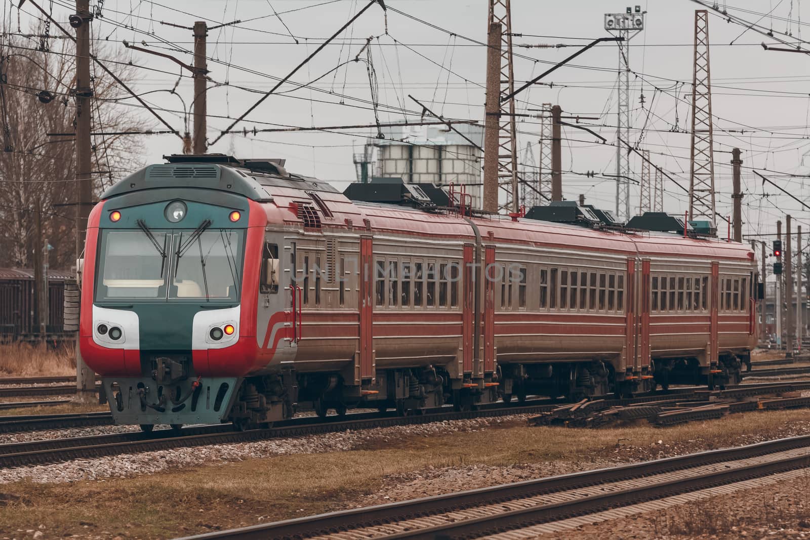 Red diesel passenger train driving at the old terminal