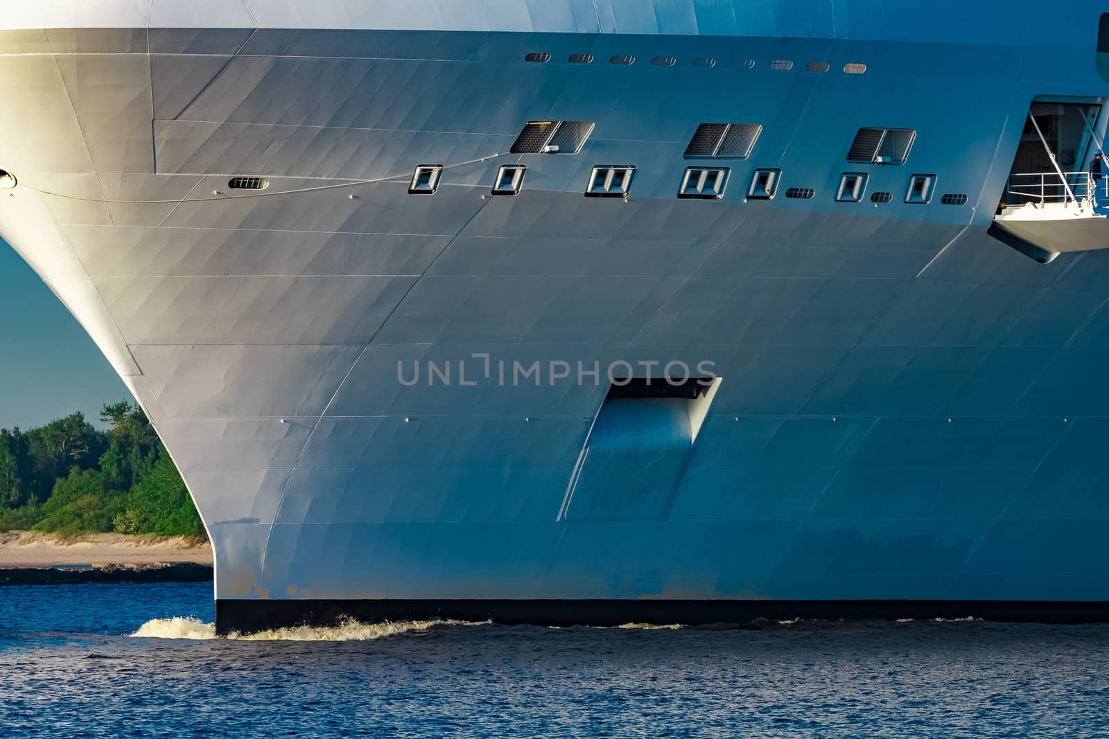 White giant brand new passenger ship moving in clear summer day