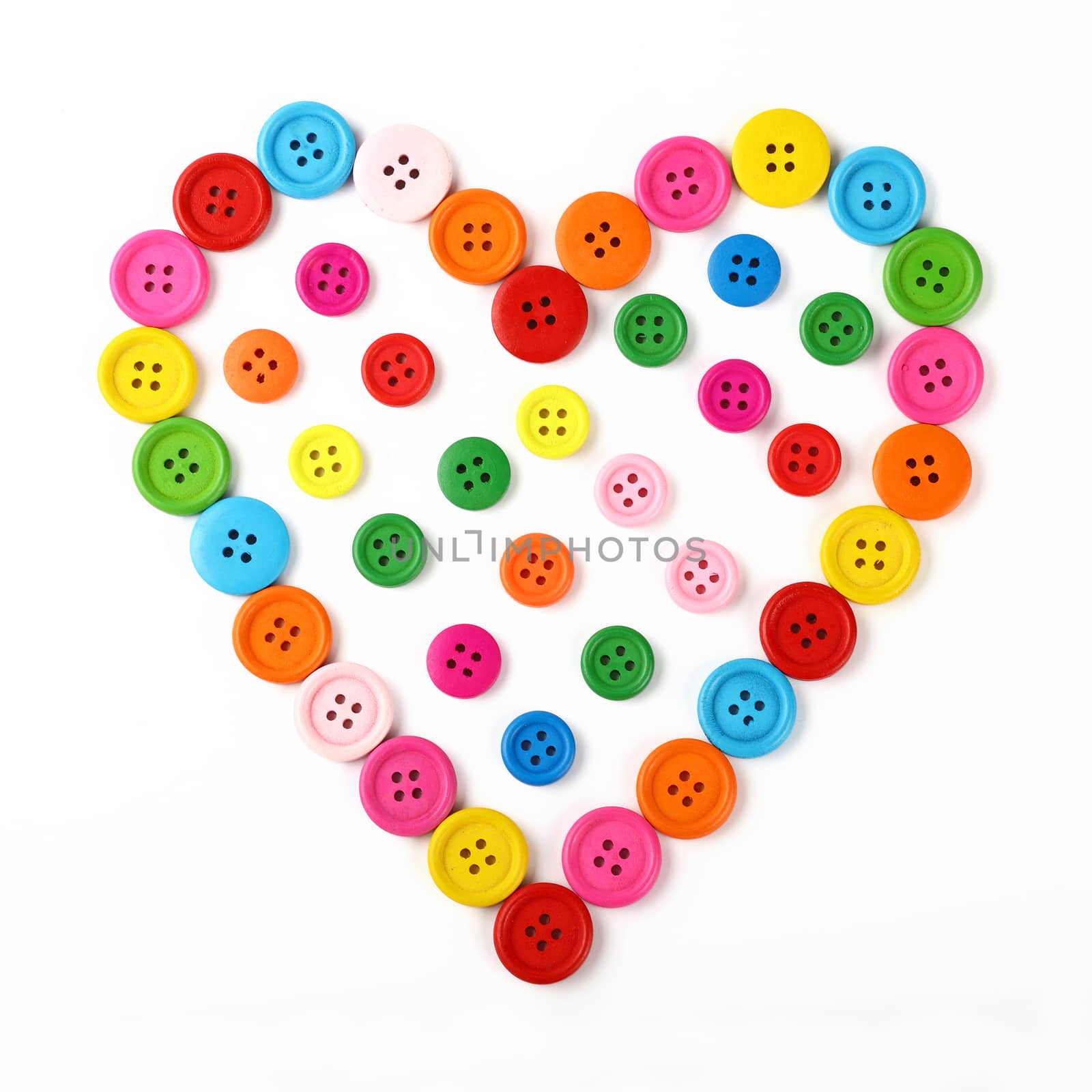 Heart shaped of colorful multicolor round painted wooden handmade sewing buttons isolated on white, close up, elevated top view