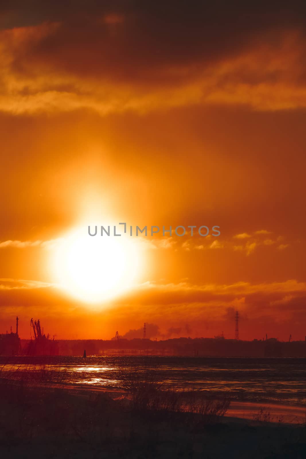 Hot orange winter sunrise against the cargo port