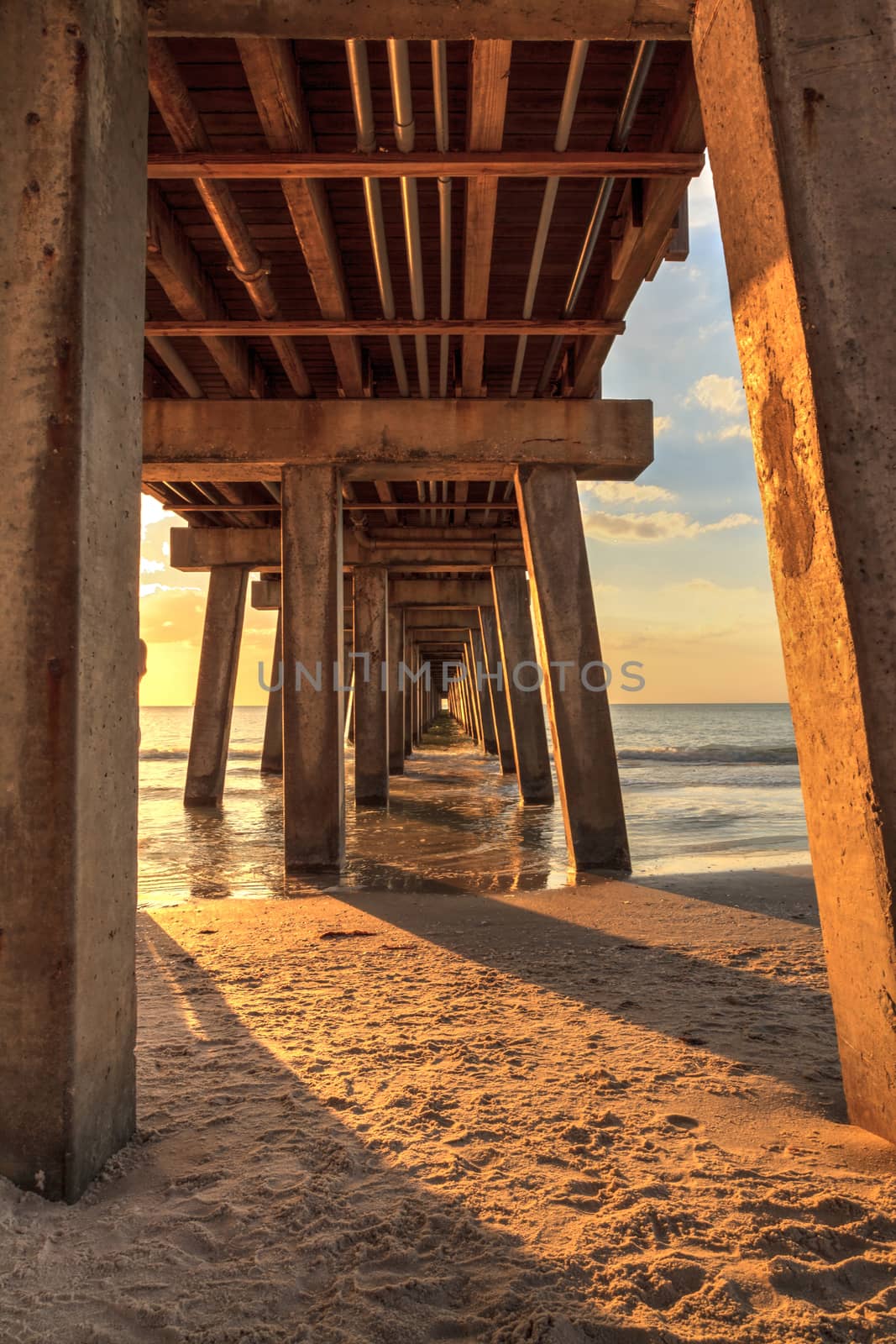 On the beach under the Naples Pier at sunset by steffstarr