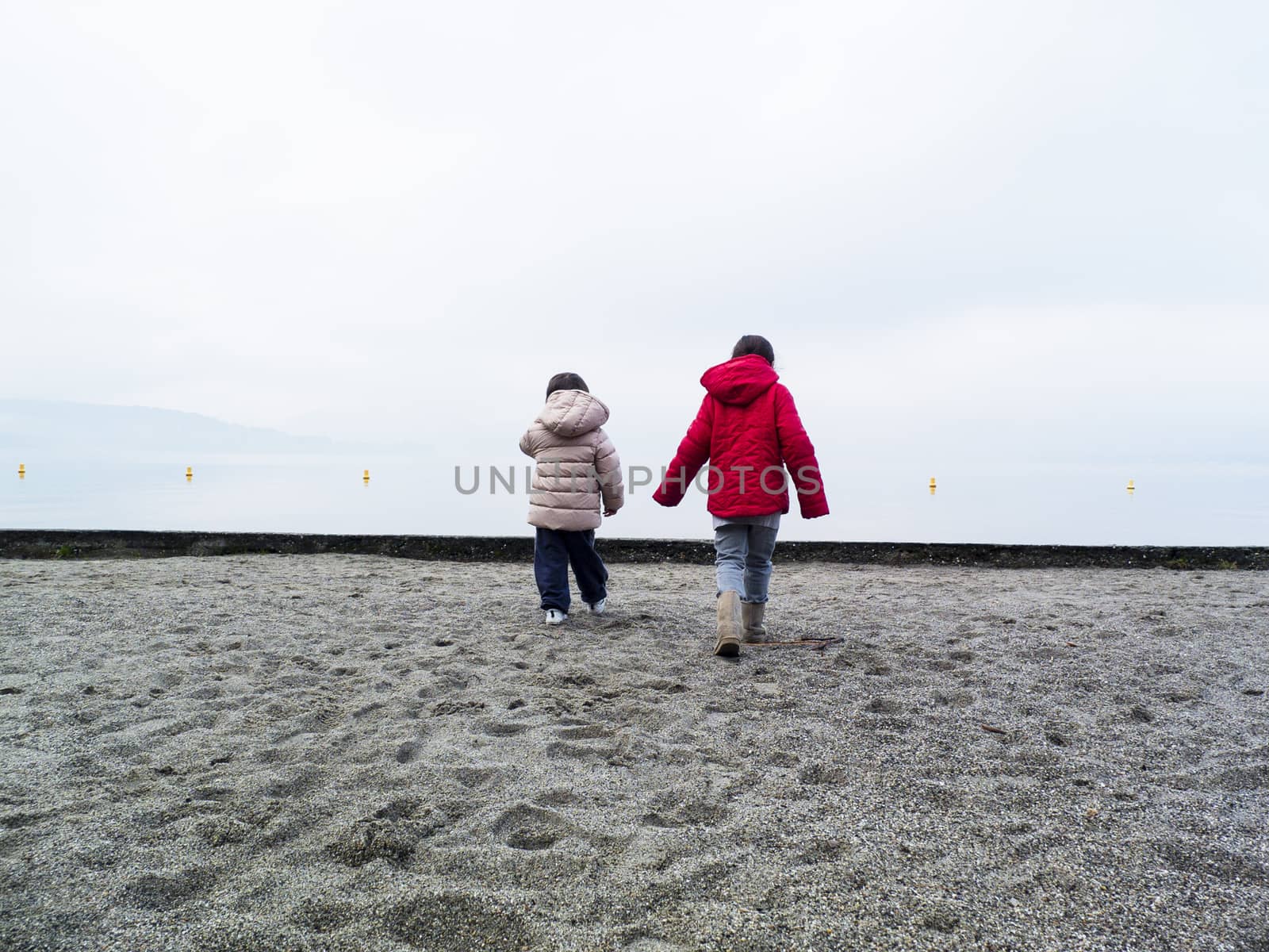 Children playing on the beach in winter, Lake Maggiore, Ispra, Lombardy, Italy