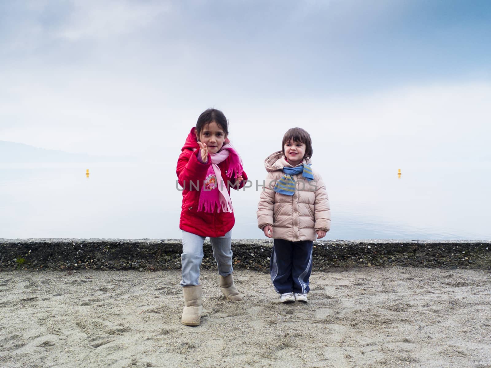 Children playing on the beach in winter, Lake Maggiore, Ispra, Lombardy, Italy