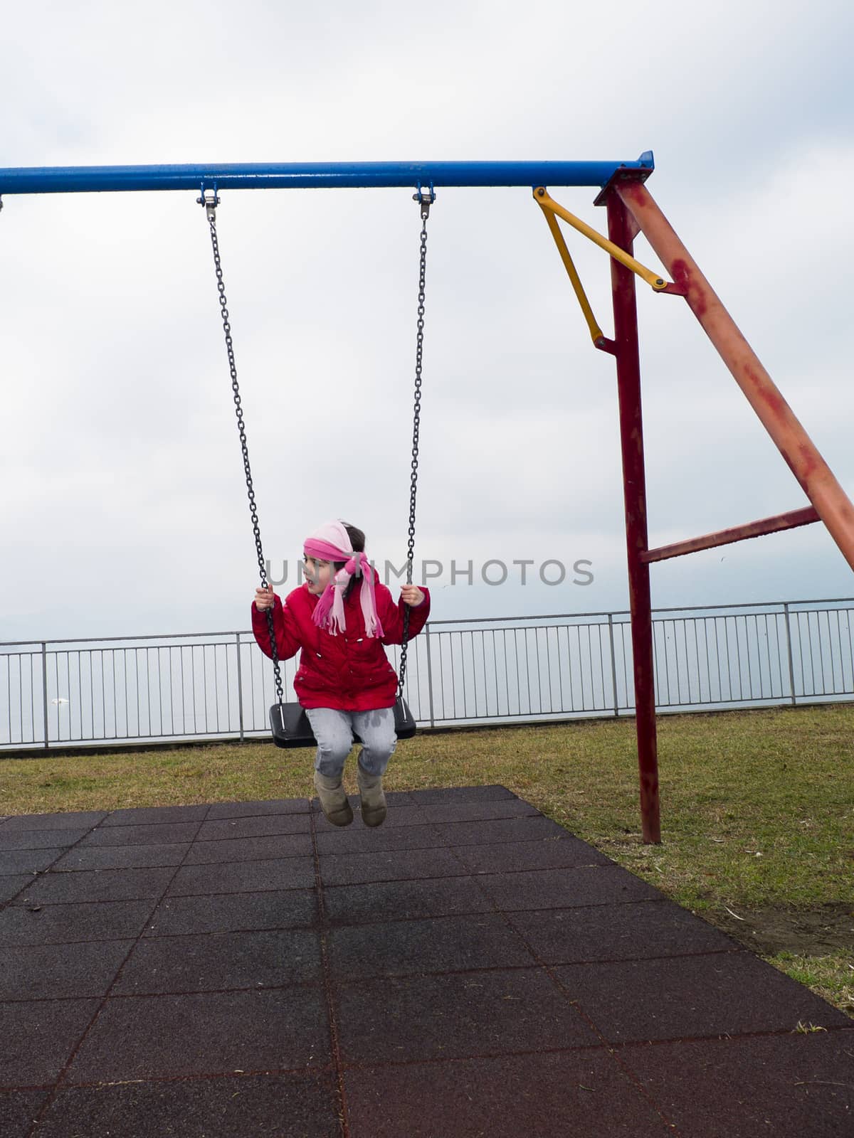 children on the swing in winter at lake maggiore,Italy