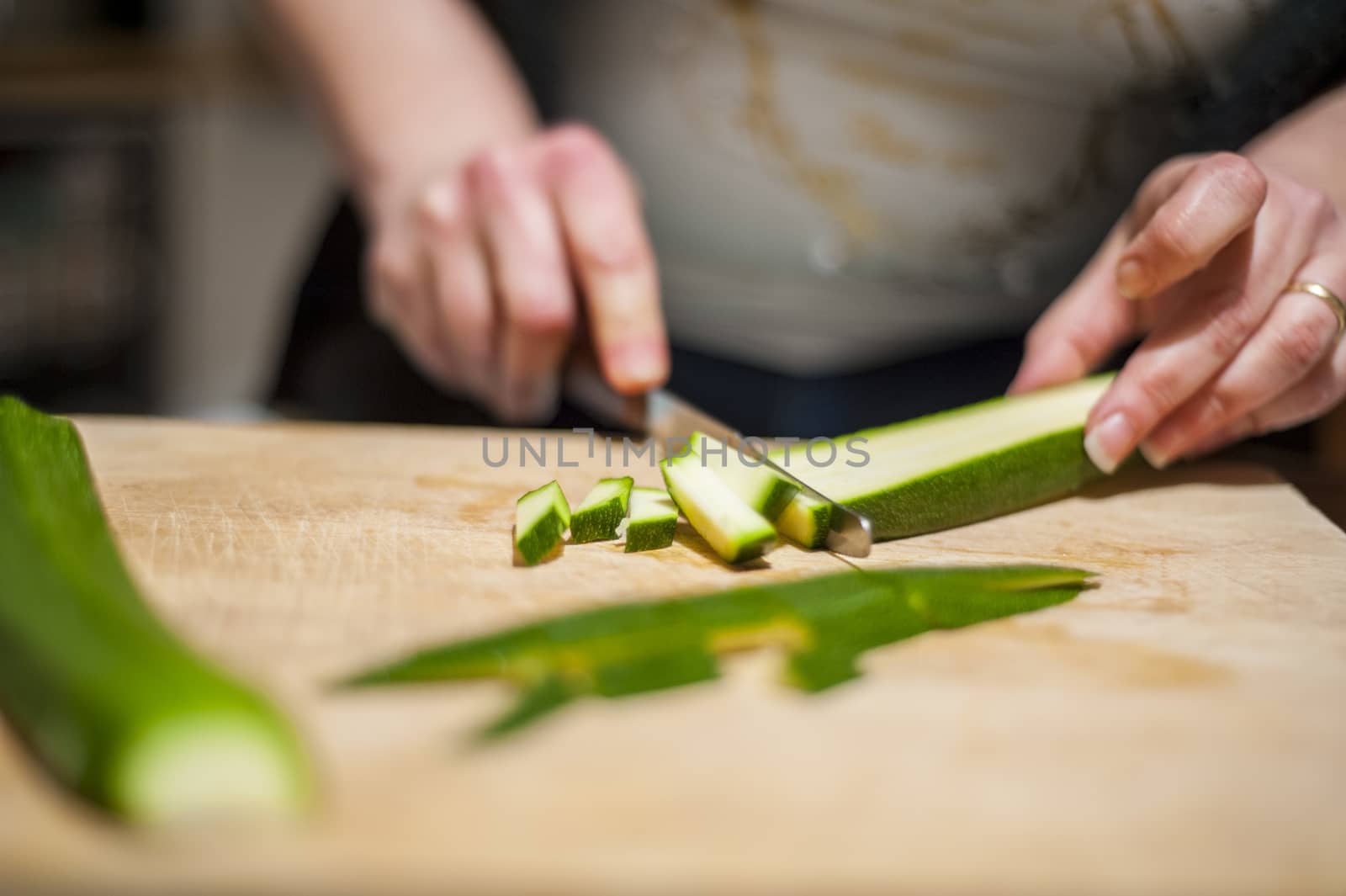 woman's hands with zucchini-cut ring on the kitchen cutting board to prepare dinner or lunch