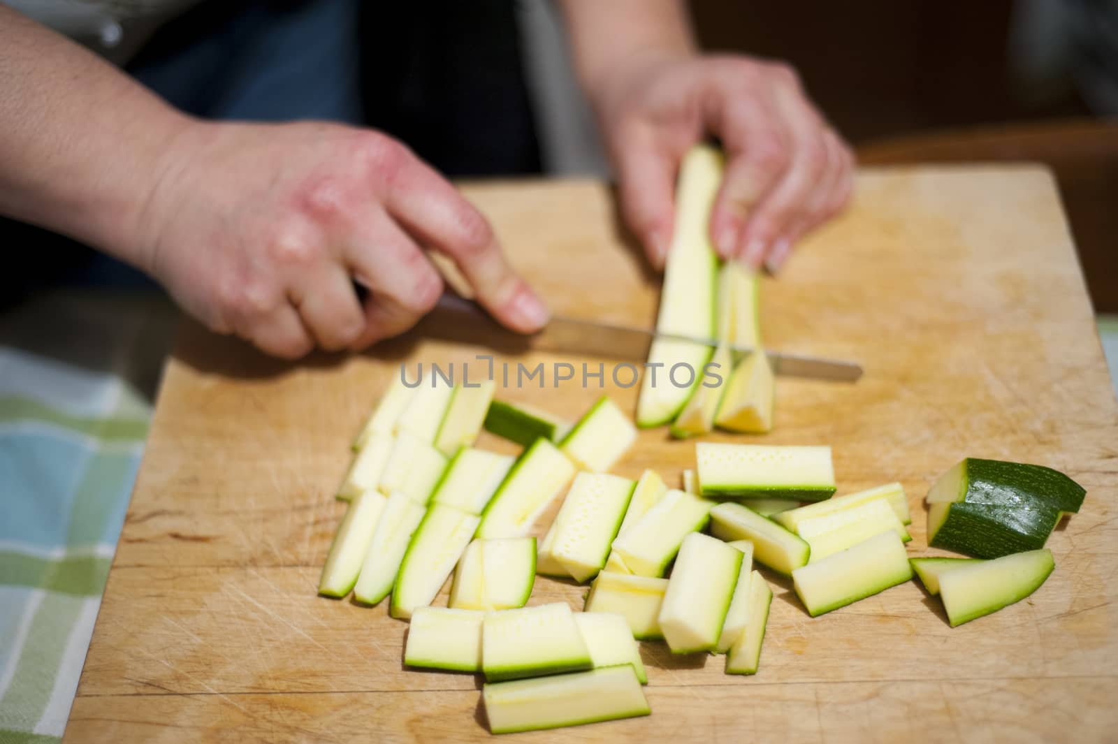 woman's hands with zucchini-cut ring on the kitchen cutting board to prepare dinner or lunch