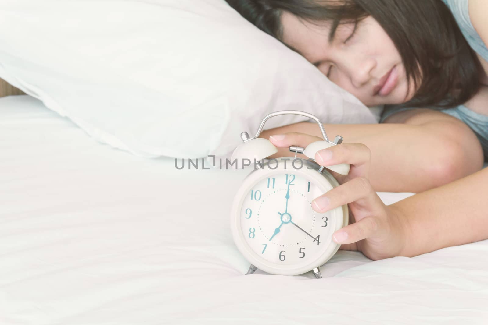 Closeup woman sleeping on the bed with alarm clock for wake up time