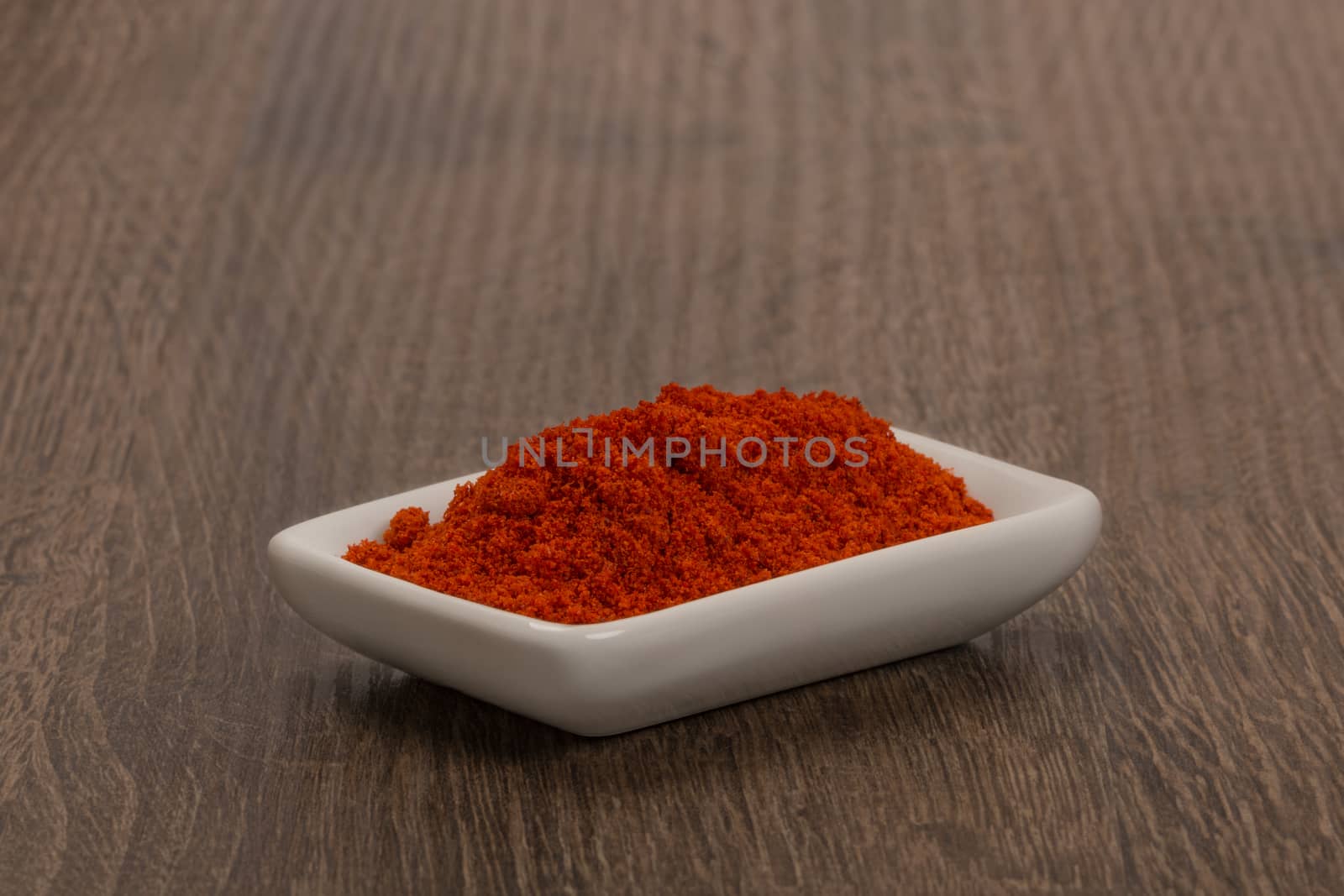 Bowl of ground red pepper spice in bowl by ivo_13